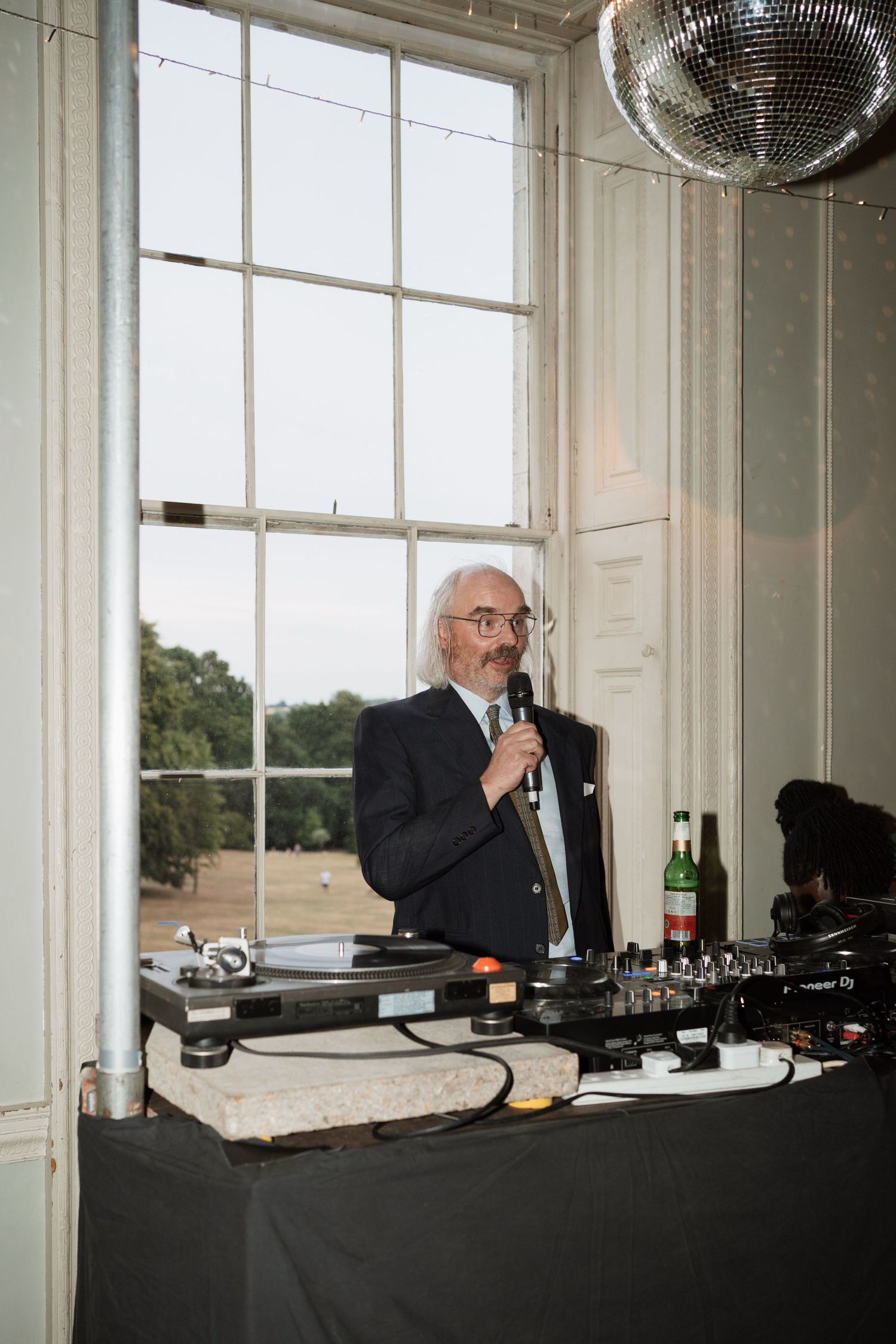 DJ setup at an event with black tablecloth and window views.