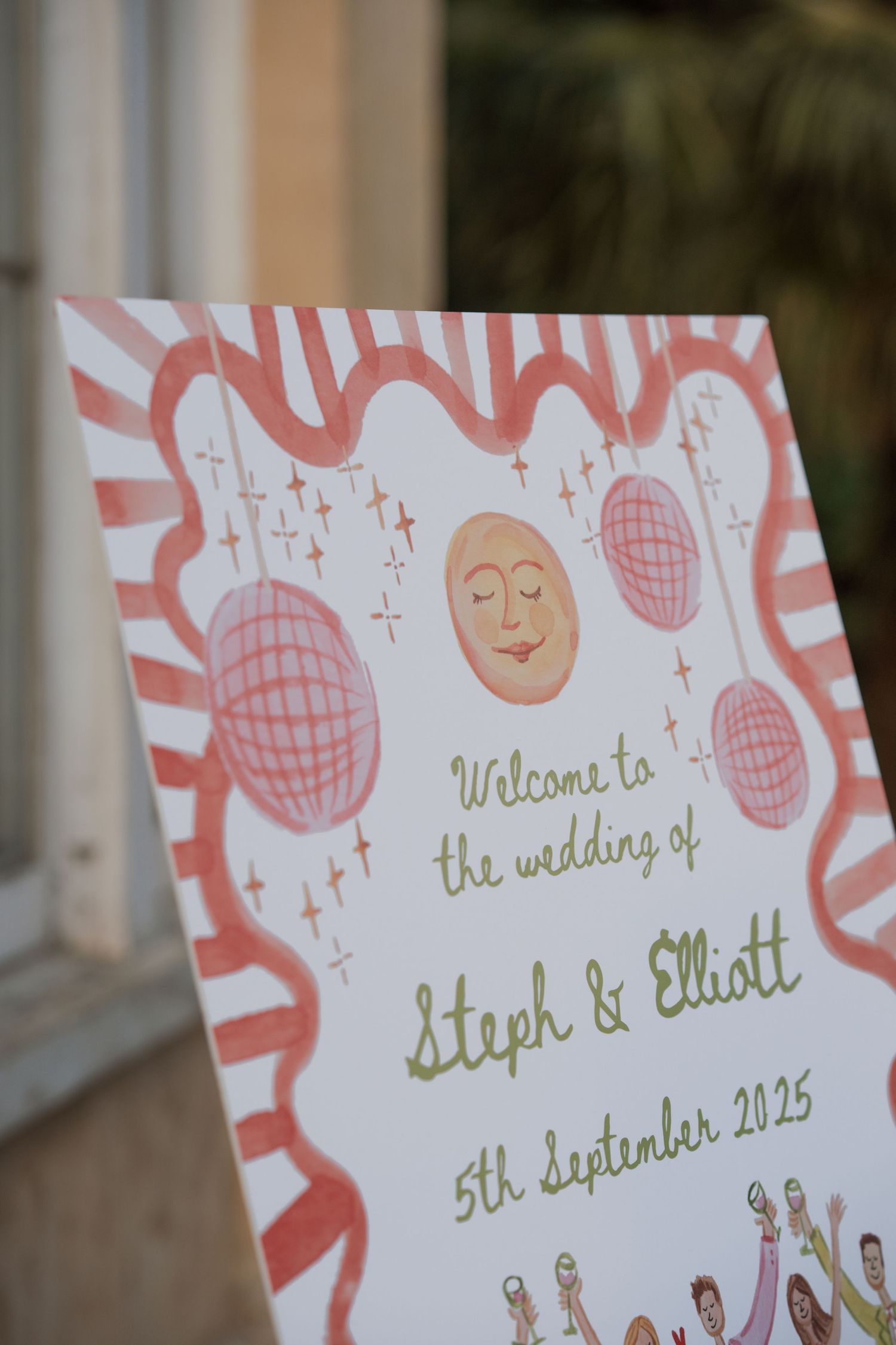 Wedding welcome signs with pink and green lettering displayed at venue entrance.