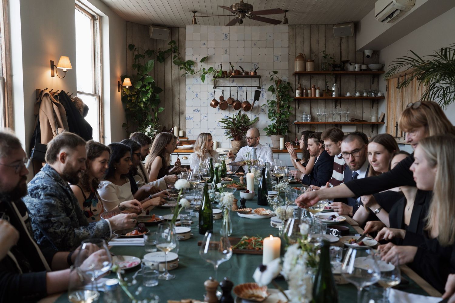 An elegant dining room with guests seated at tables under ceiling fans.