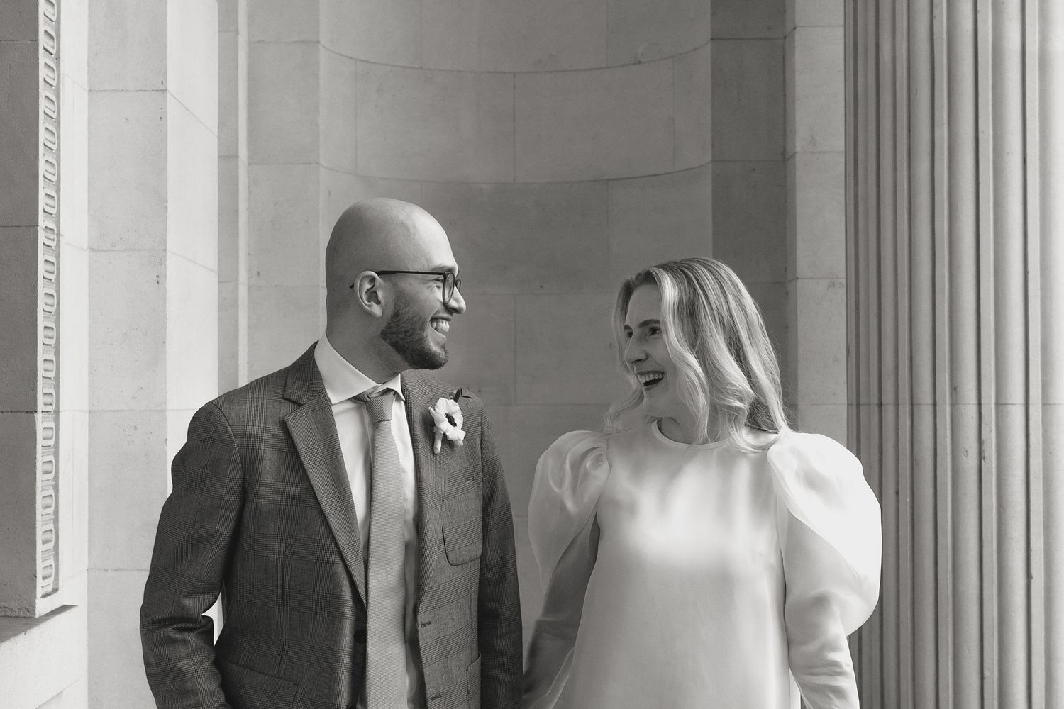 Intimate black and white wedding portraits in an elegant columned hallway.