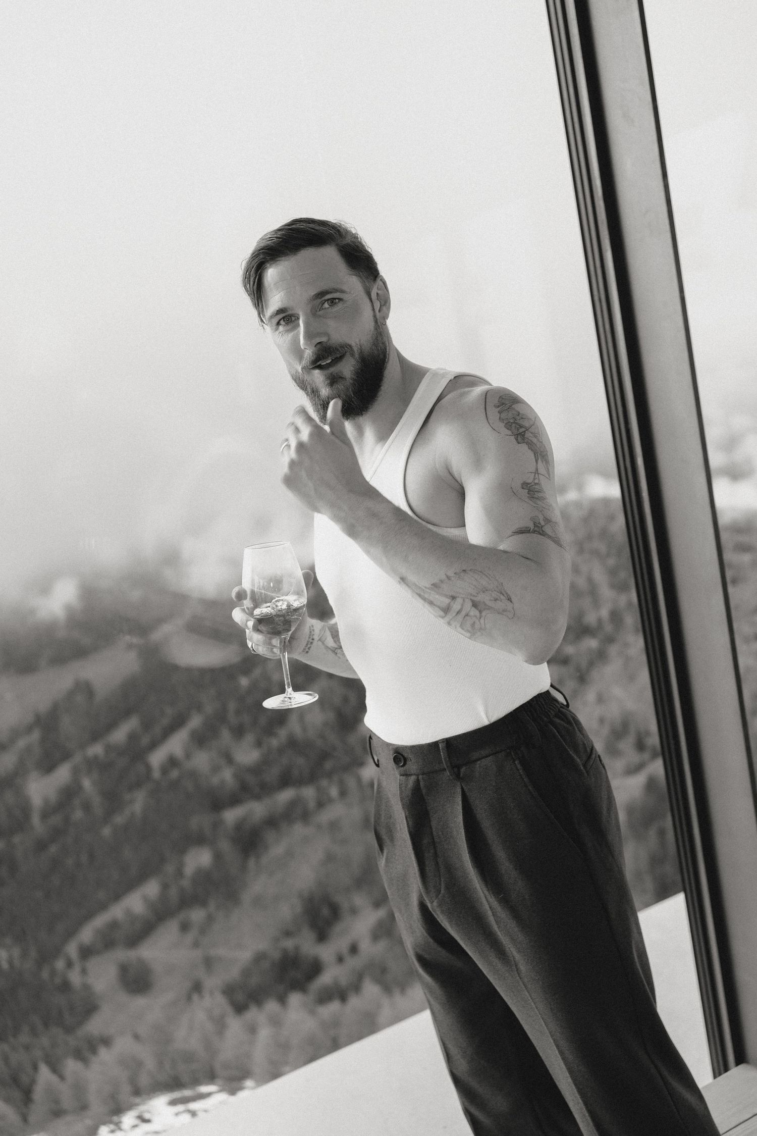 Series of black and white photos showing someone dancing by a window with mountain views.