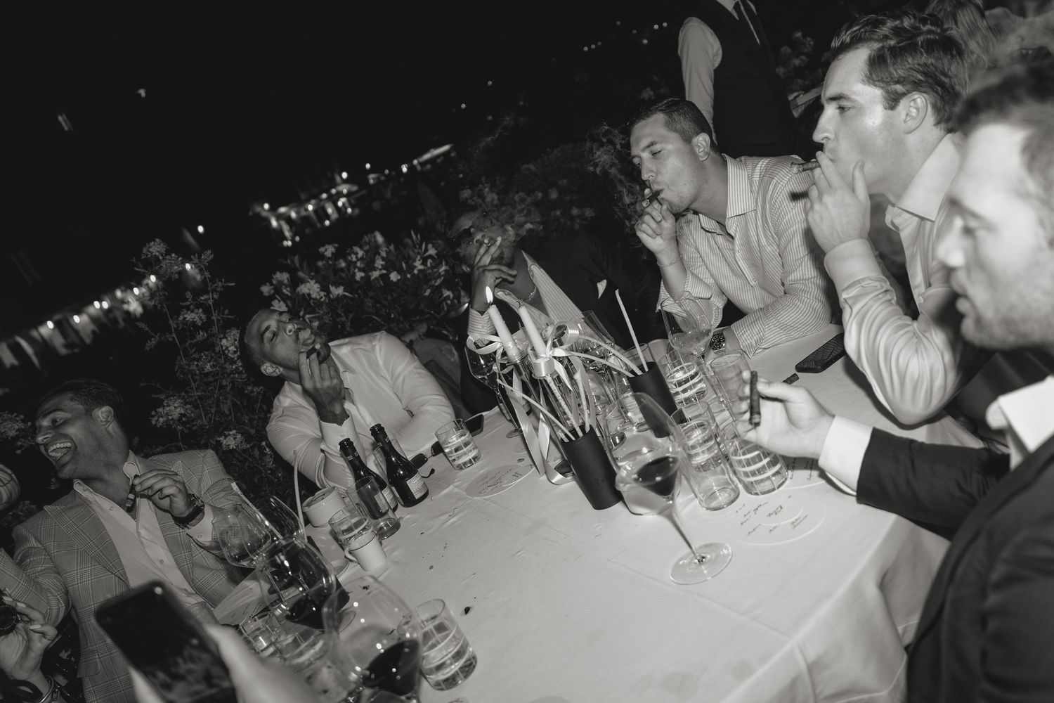 Wedding reception guests seated at long tables during an evening celebration.
