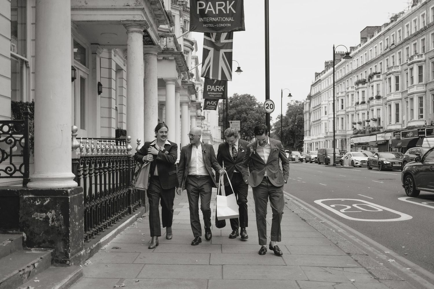 Urban street scene with people walking past historic buildings.