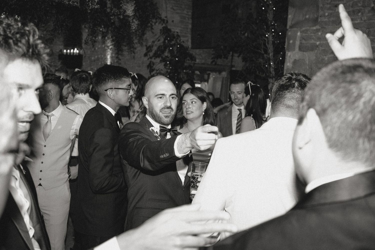 Wedding guests in formal attire dancing and celebrating at a reception.