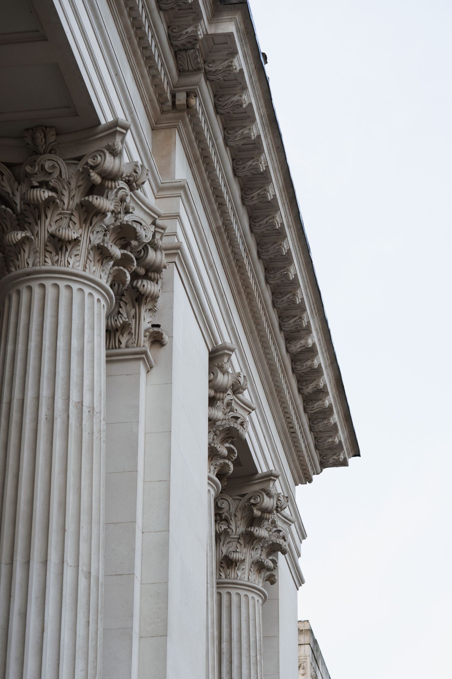Architectural detail of classical white stone columns with ornate Corinthian capitals.