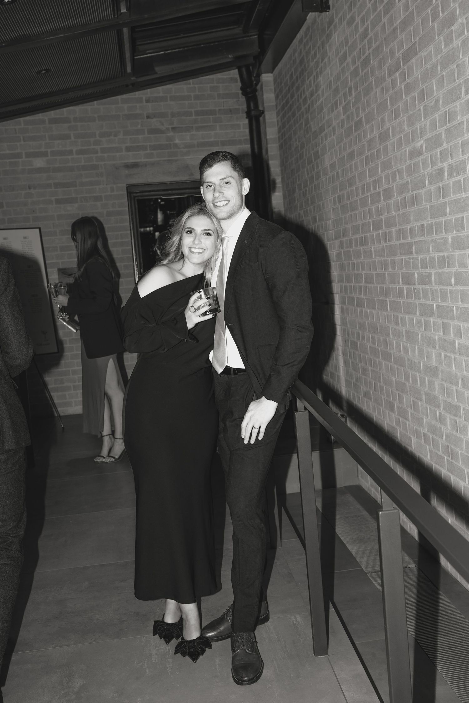 Guests posing in a hallway during a formal evening event.