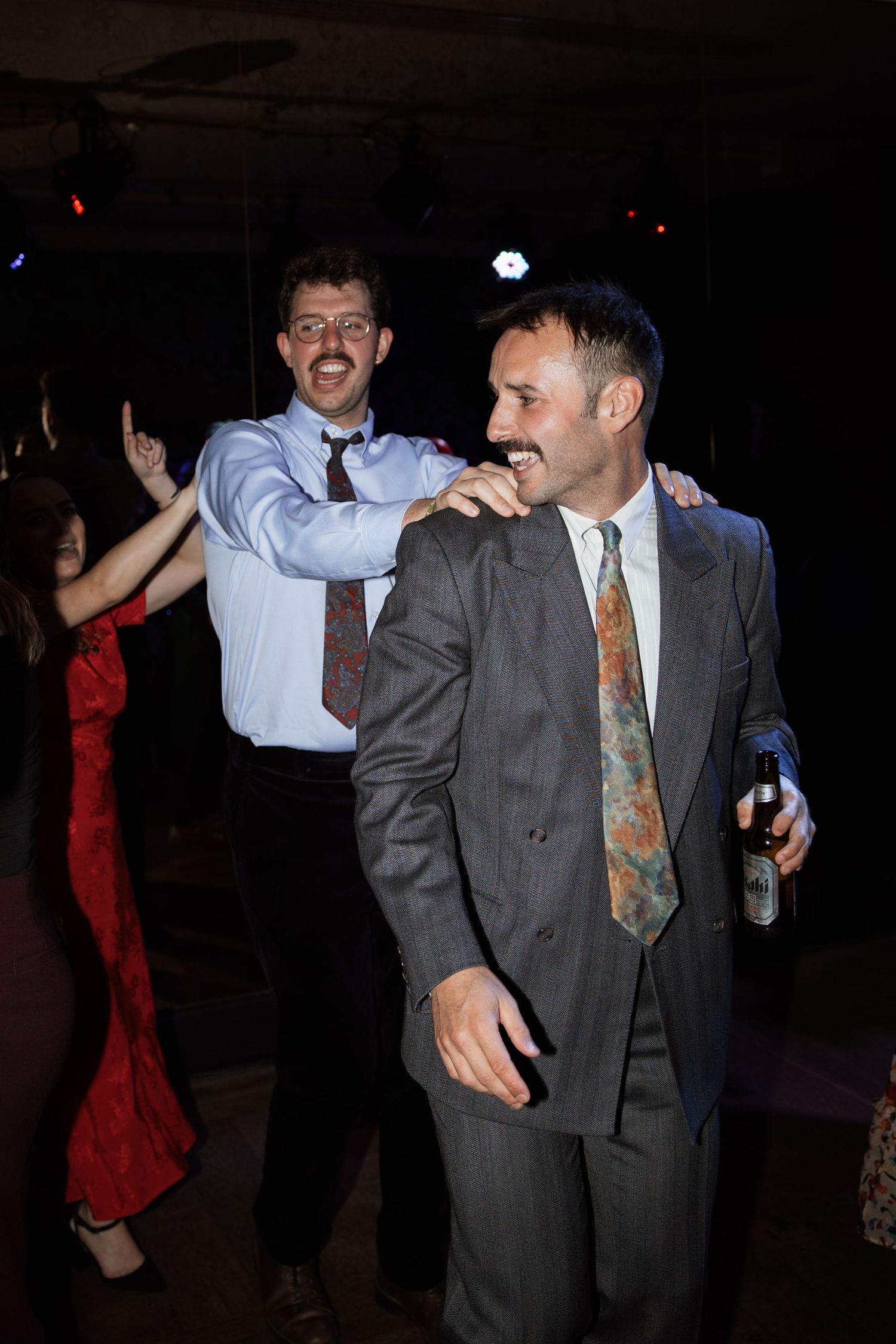 Guests dancing and celebrating at a lively party with people in formal attire.