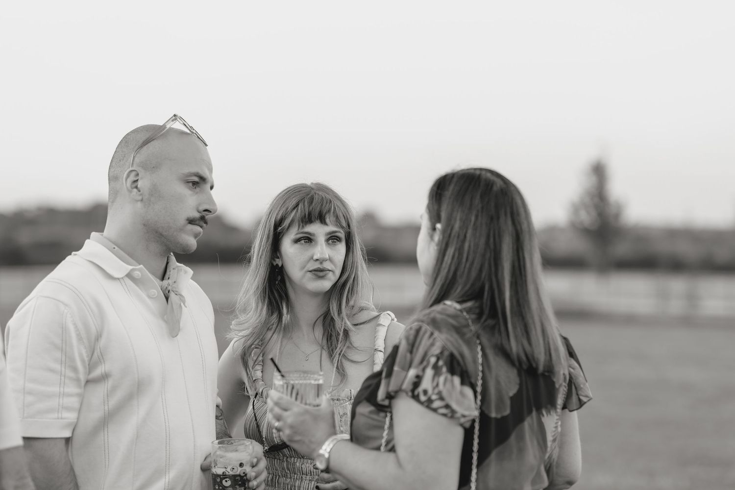 Group of people sharing drinks and laughs at an outdoor gathering.