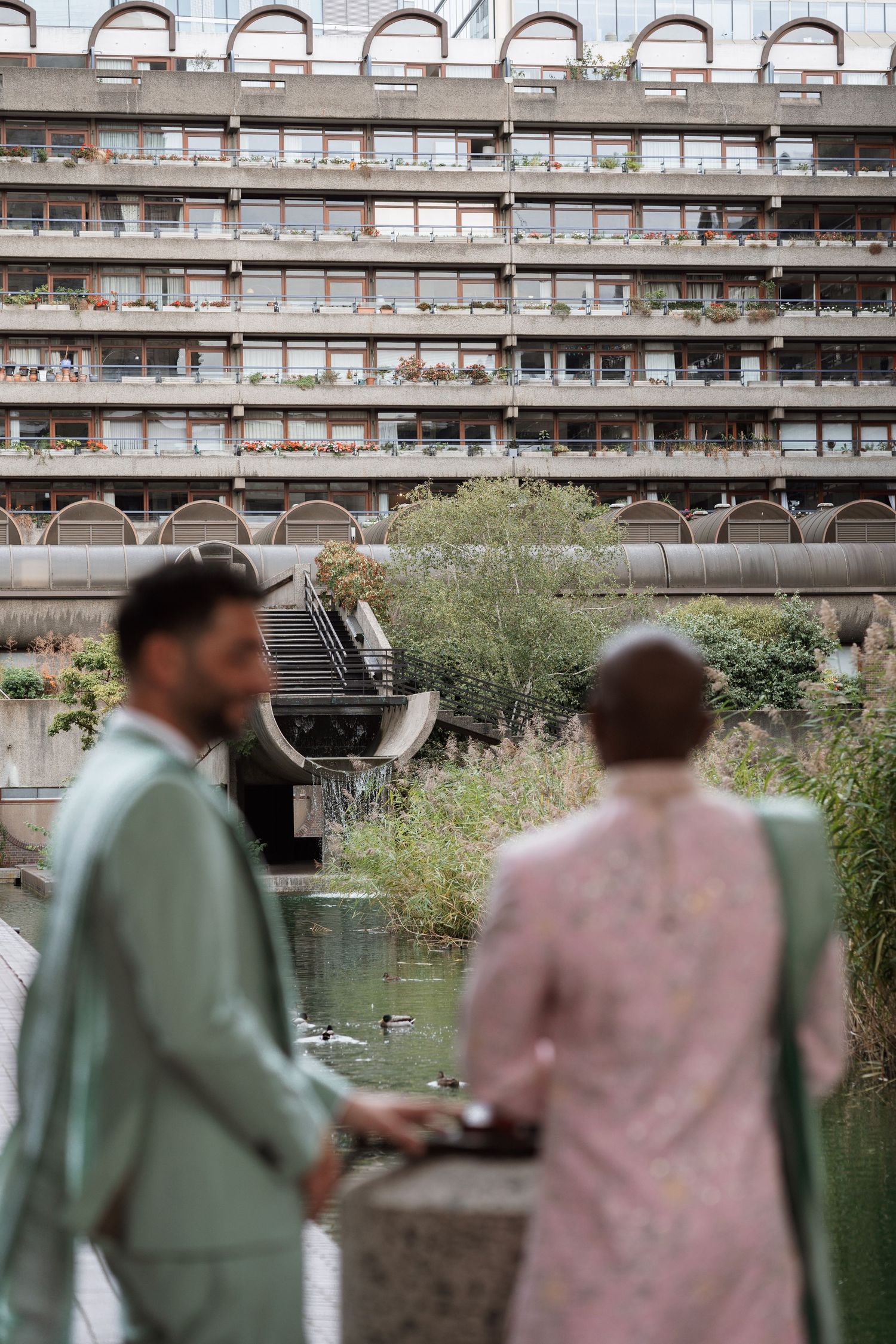 Urban architecture with concrete arches and balconies serving as backdrop for formal portraits.