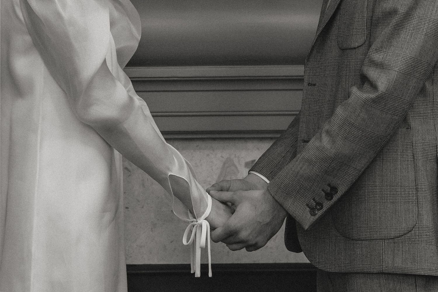 A black and white photograph capturing an intimate wedding ceremony moment.