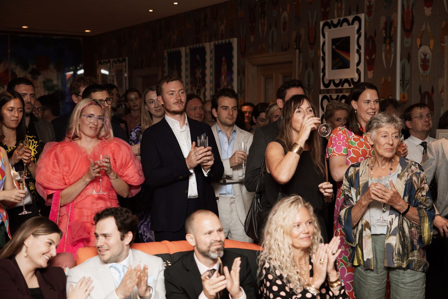 Crowd of party guests watching and reacting during a celebration event.
