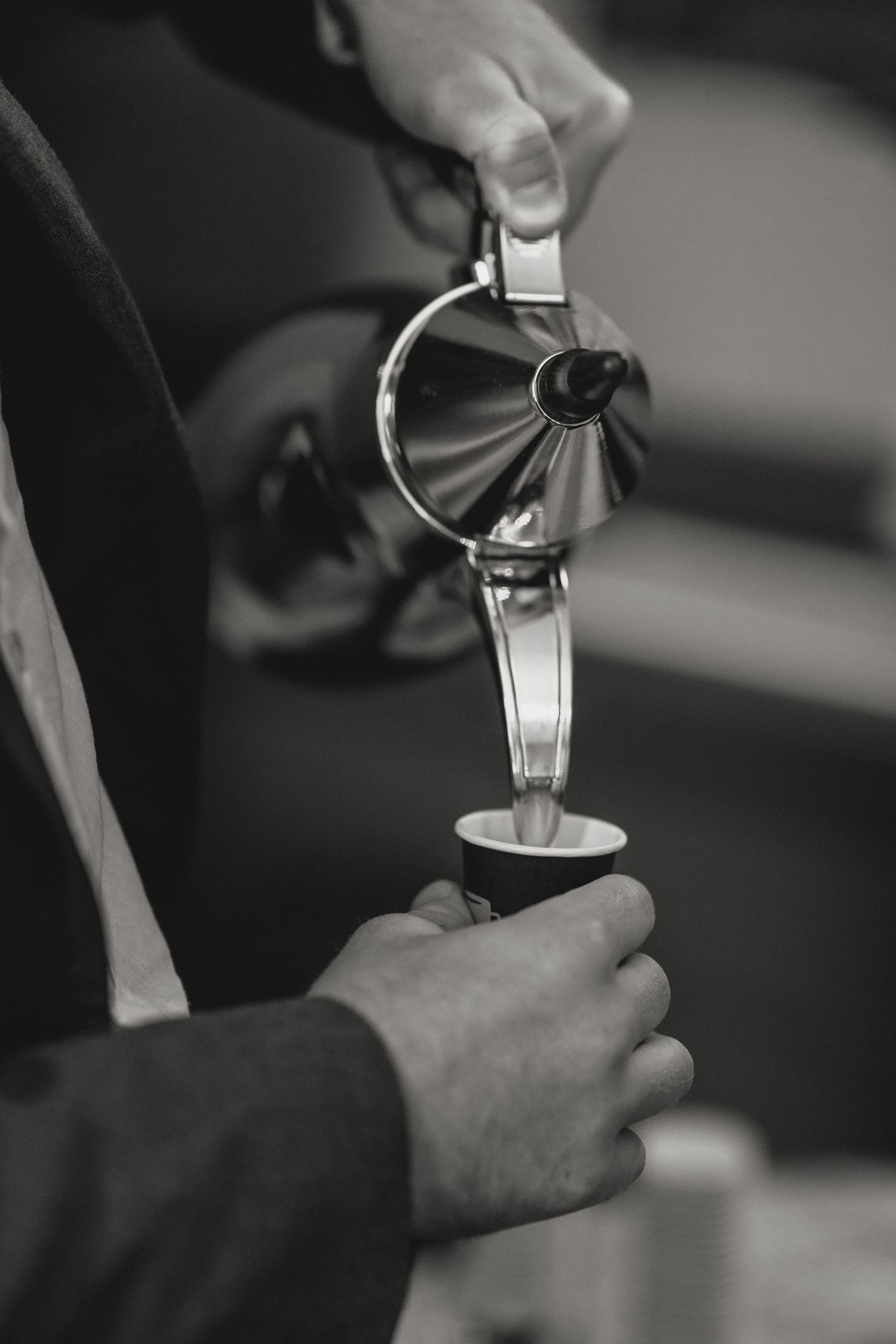 Close-up black and white shot of hands pouring wine or champagne.