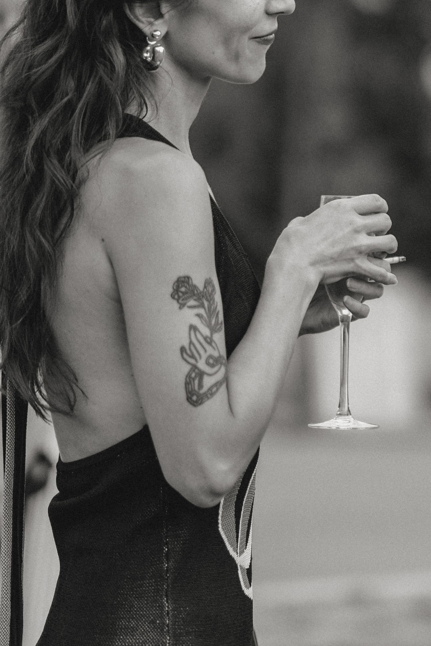 Close-up view of someone in black attire with a visible tattoo.
