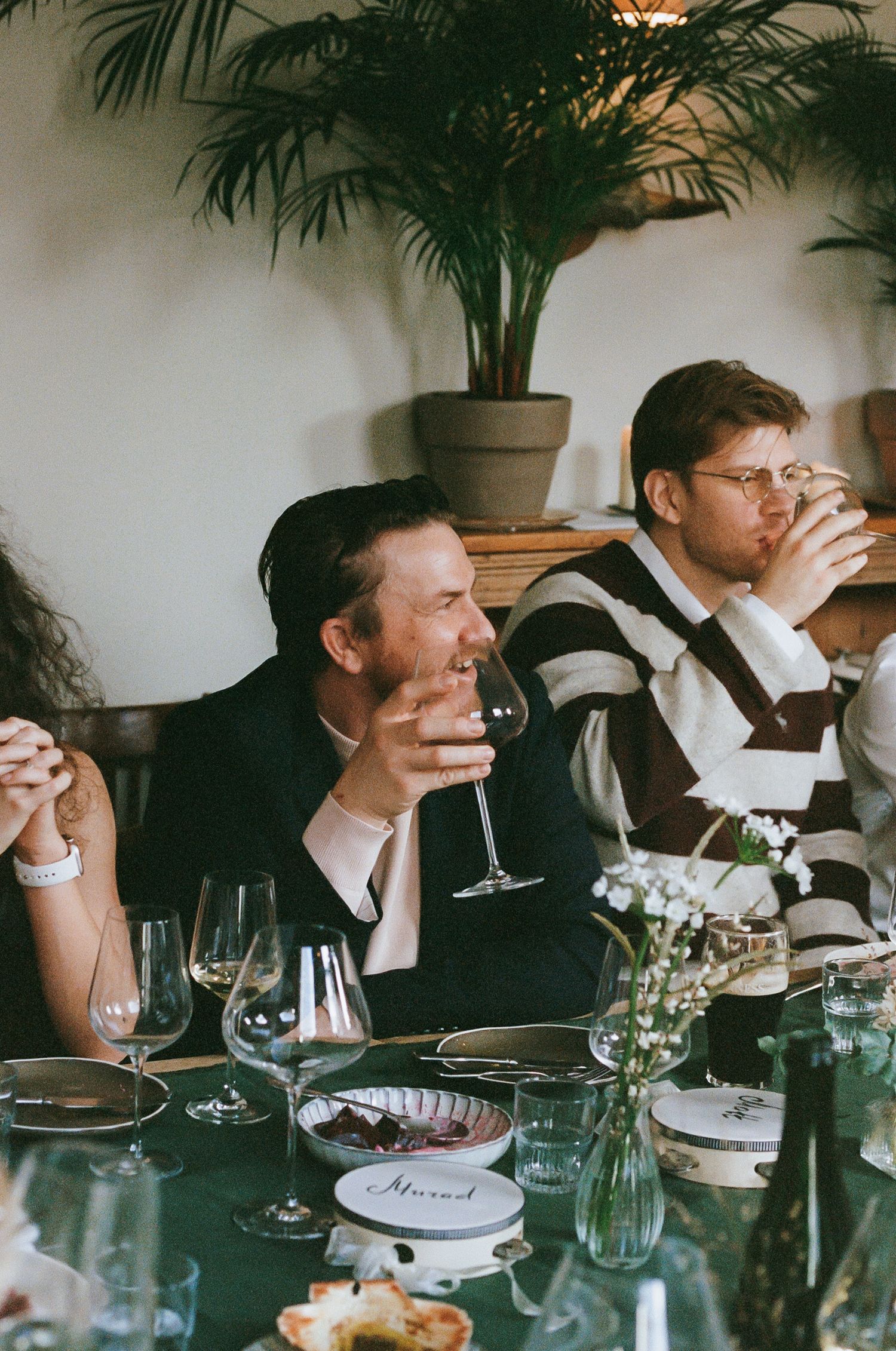 Diners enjoying wine and conversation at a formal dinner party.