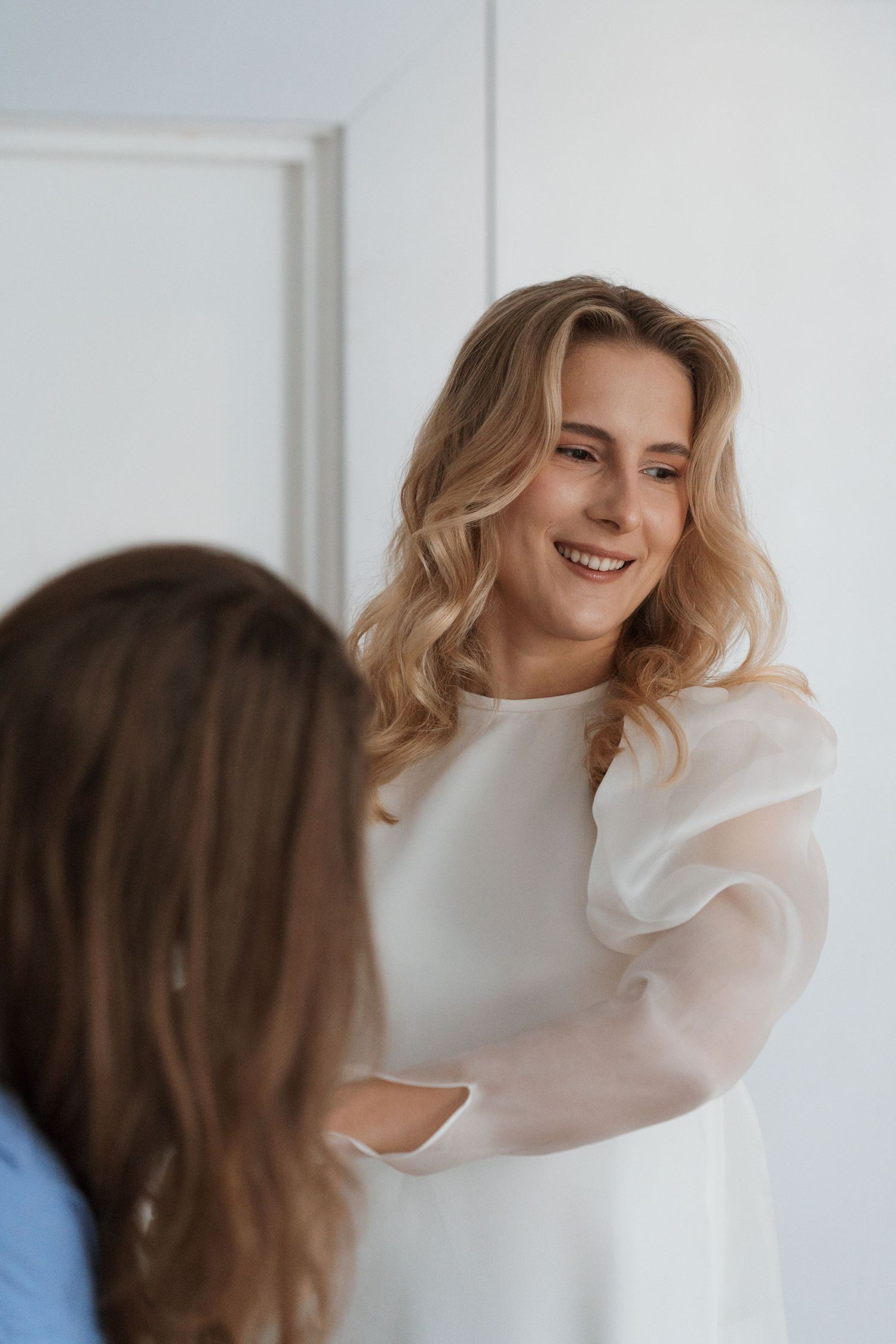 A series of portraits showing joyful expressions in a white outfit against a light background.