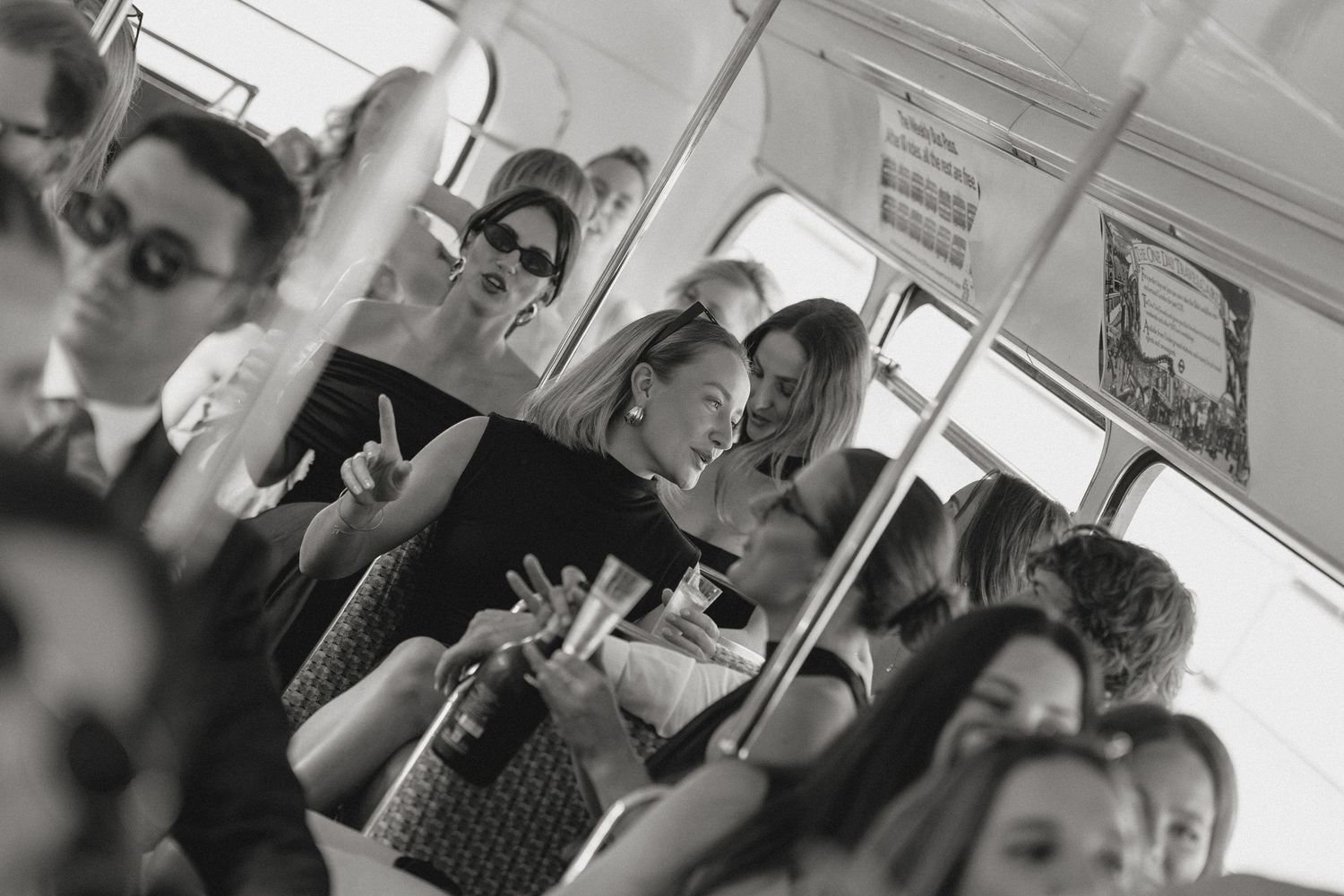 Wedding guests enjoying drinks and conversation inside vintage bus.