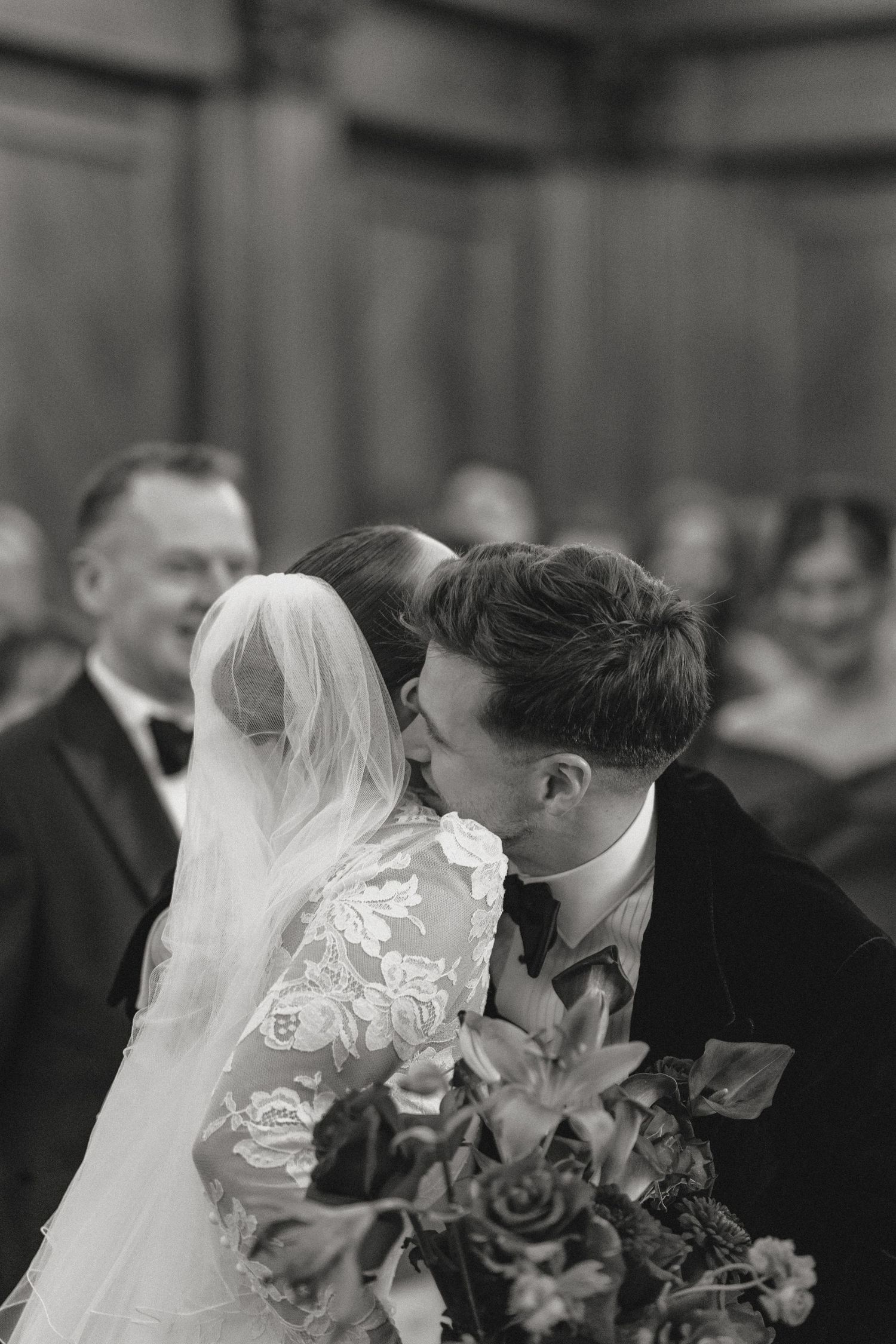 Wedding ceremony scene with bride and groom holding bouquets.