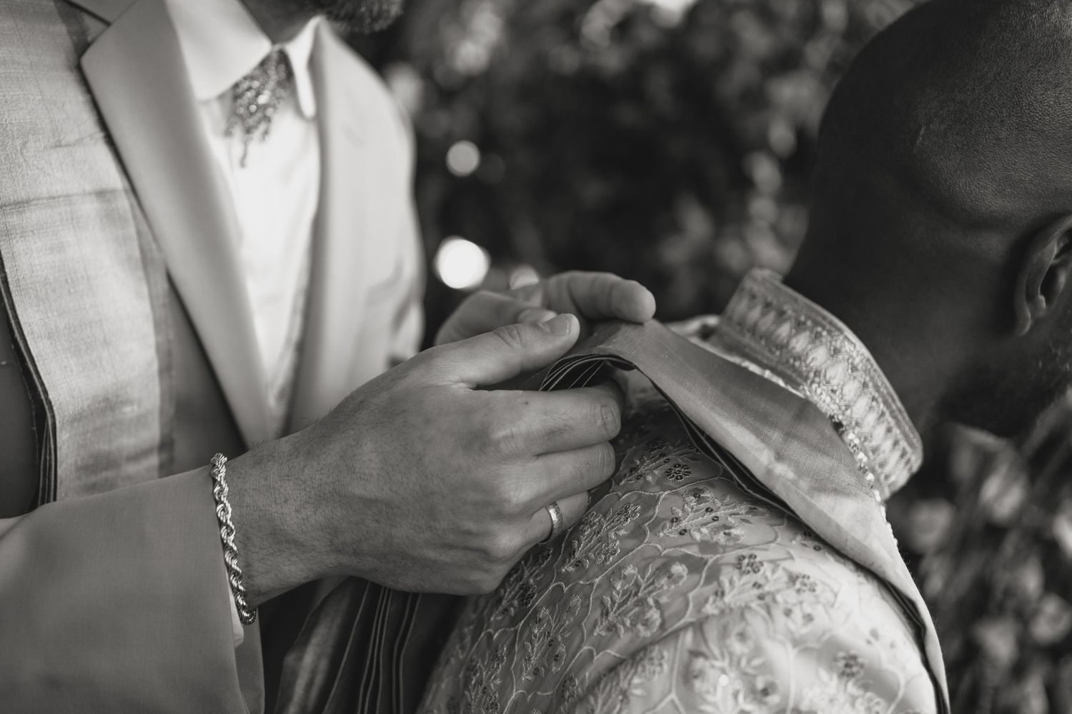 Close-up black and white photo showing details of formal attire.