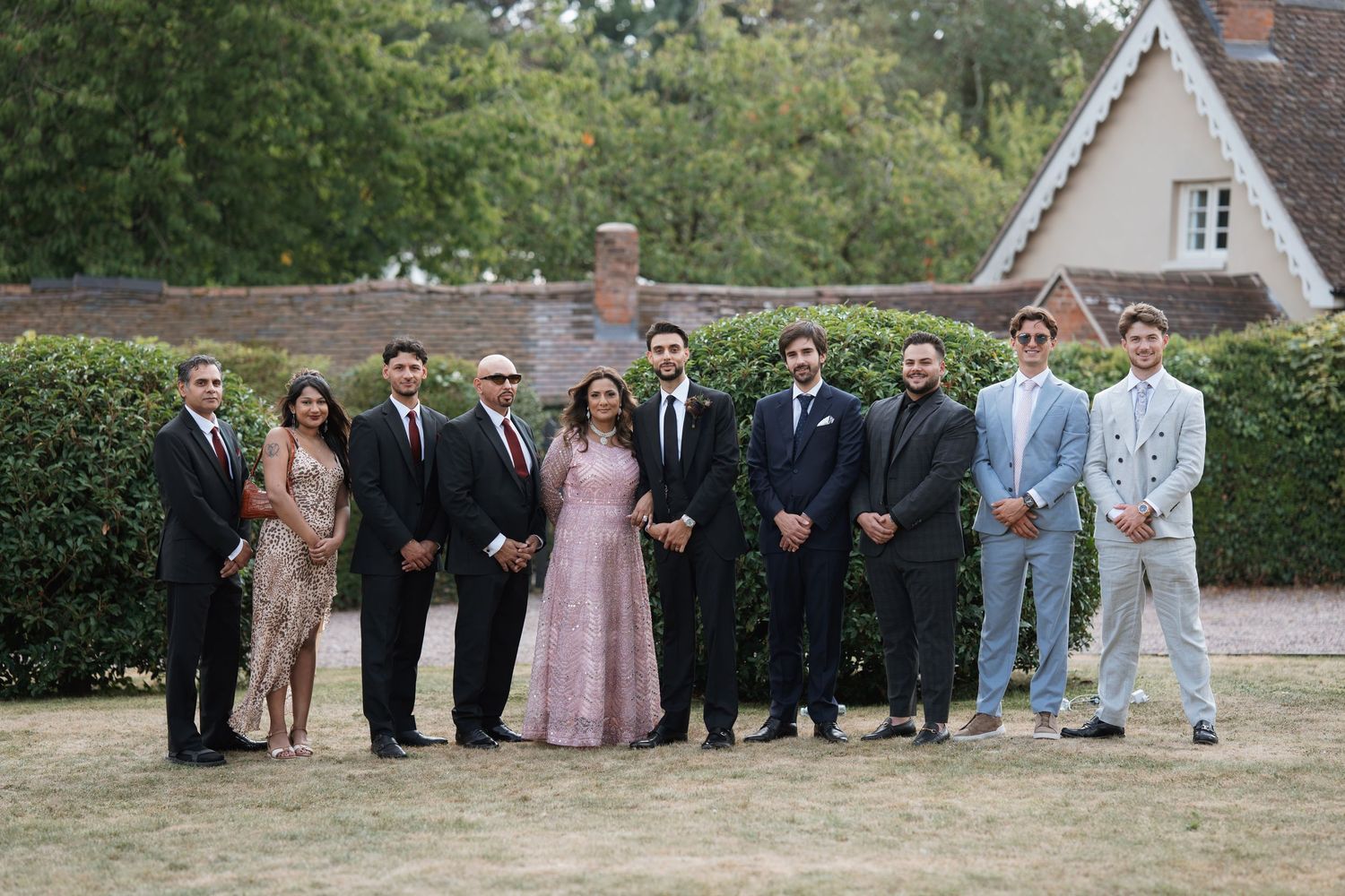 Wedding party members lined up outdoors for formal group photos in various poses.