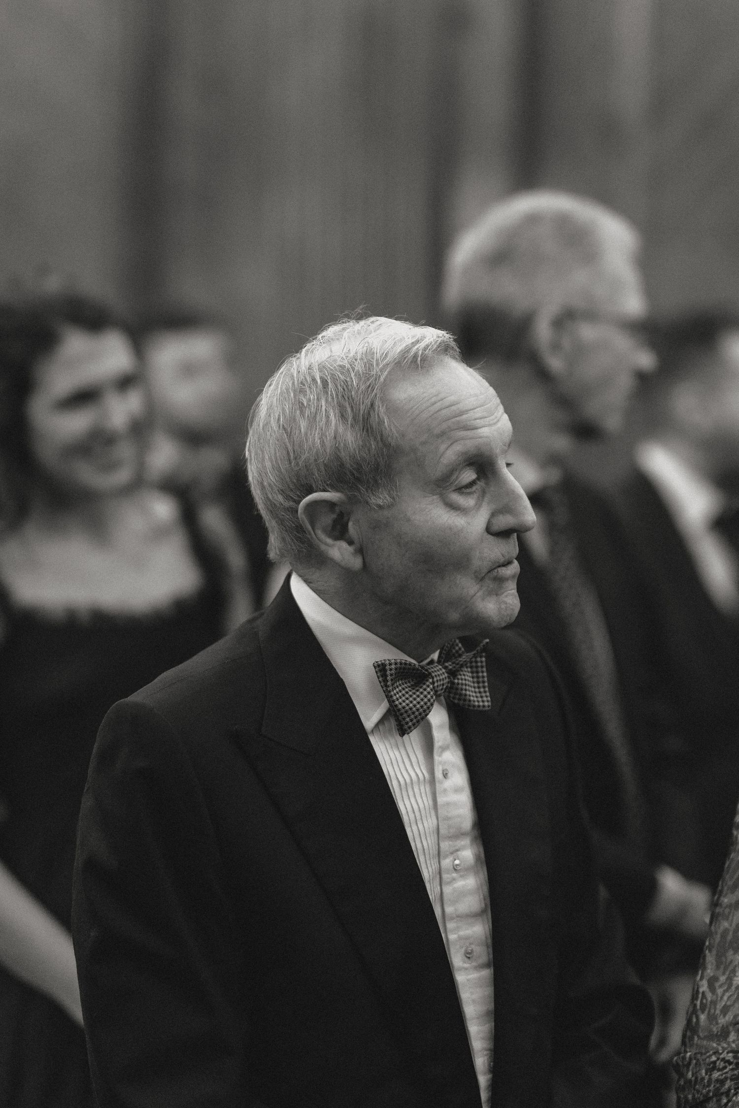 Black and white portrait of attendees at a formal event in suits.