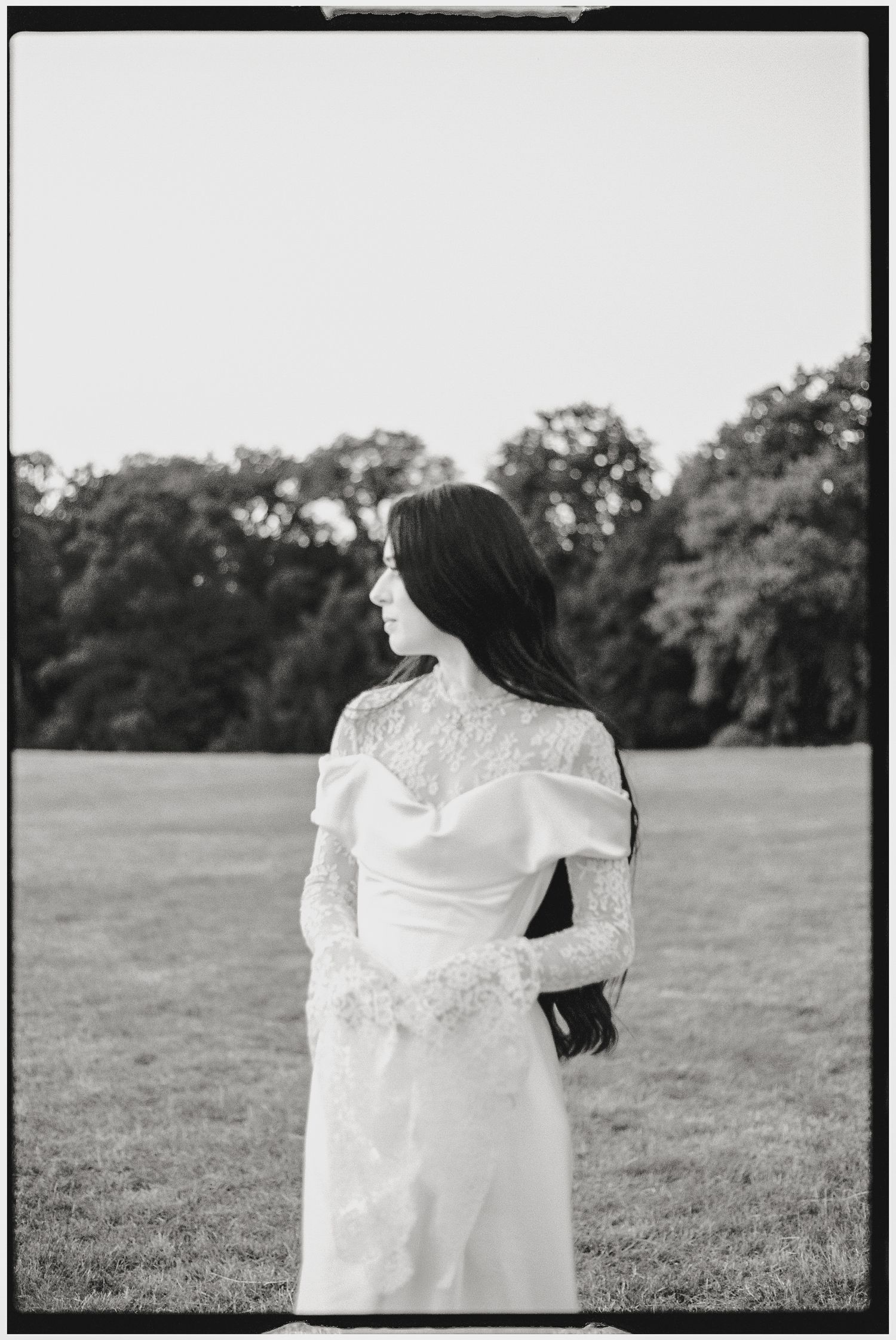 Black and white portrait of bride in lace wedding dress.
