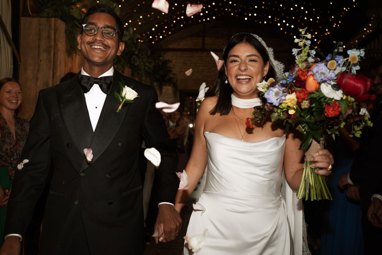 Wedding celebration with guests in formal attire dancing and celebrating at an elegant indoor reception.