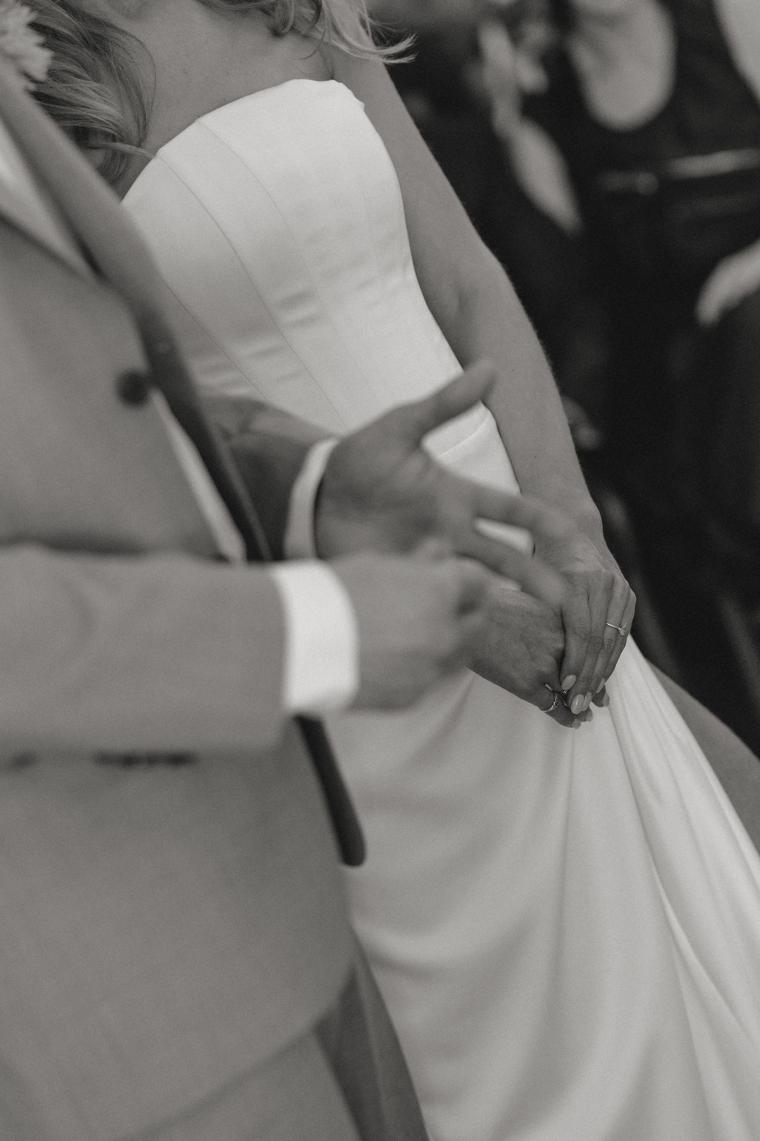 Close-up details of an elegant white wedding dress with gathered fabric and delicate draping.