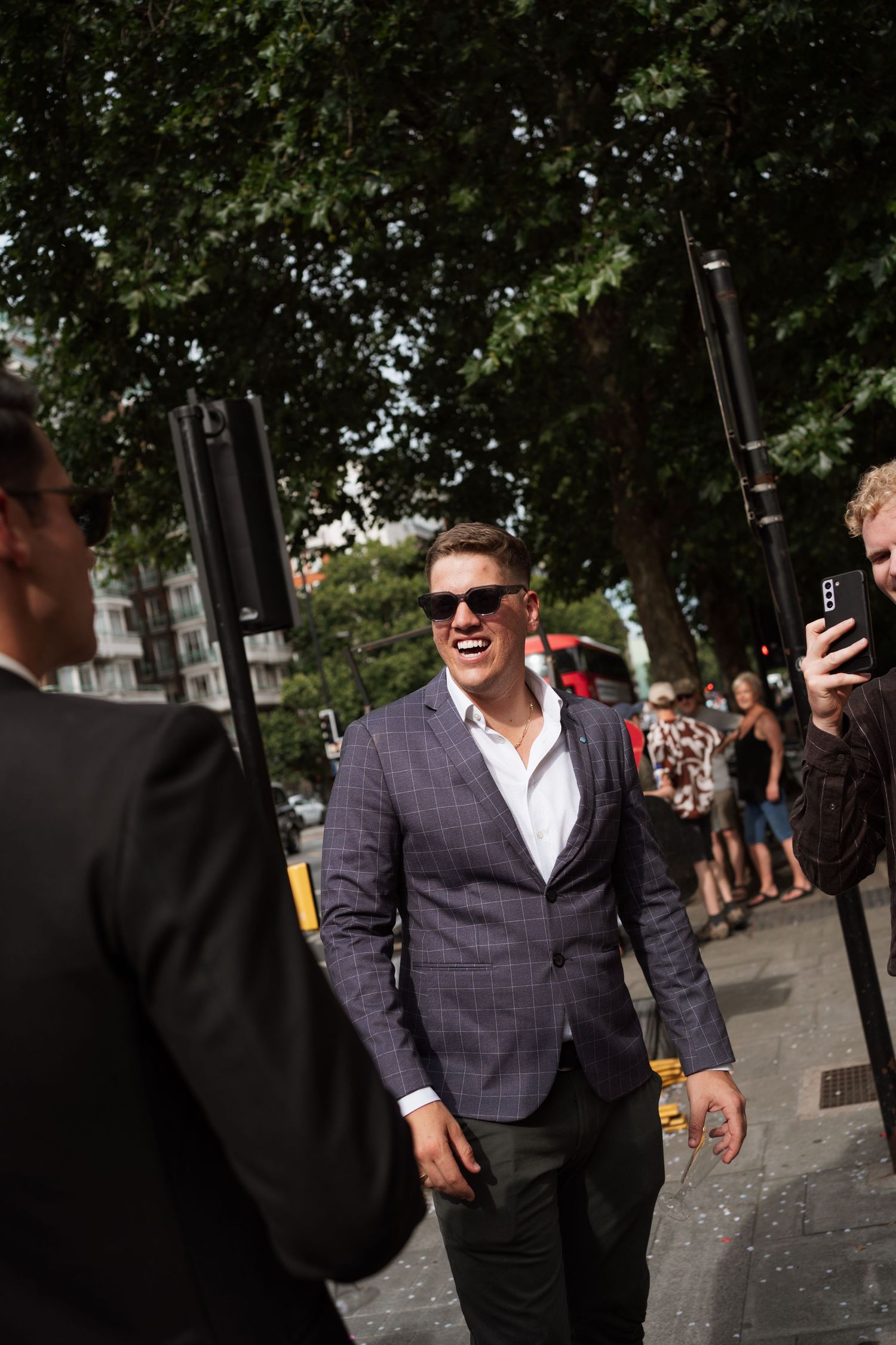 Wedding guests socializing on a sunny day outside.