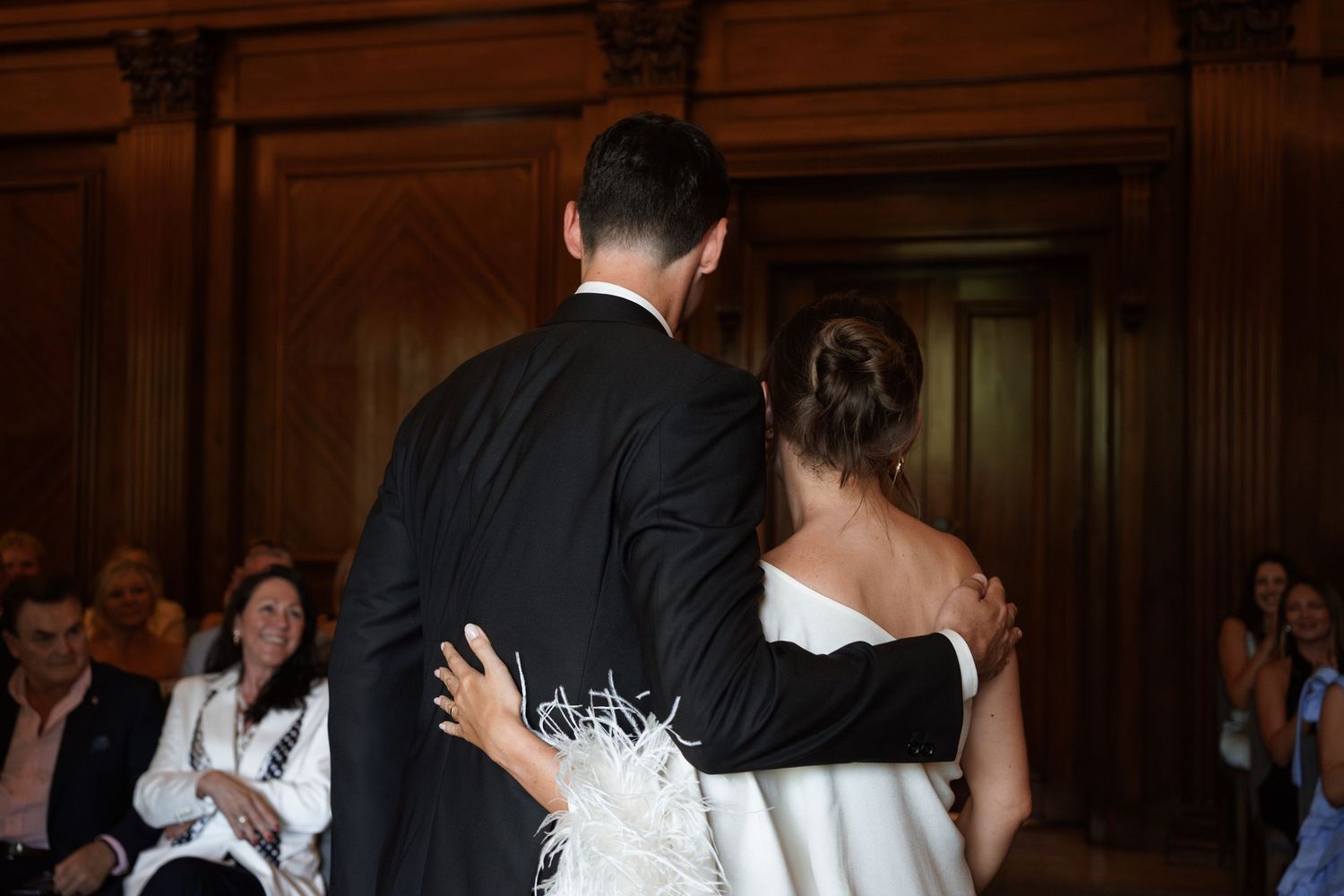 Dancing couple in formal attire with white feathered dress detail.
