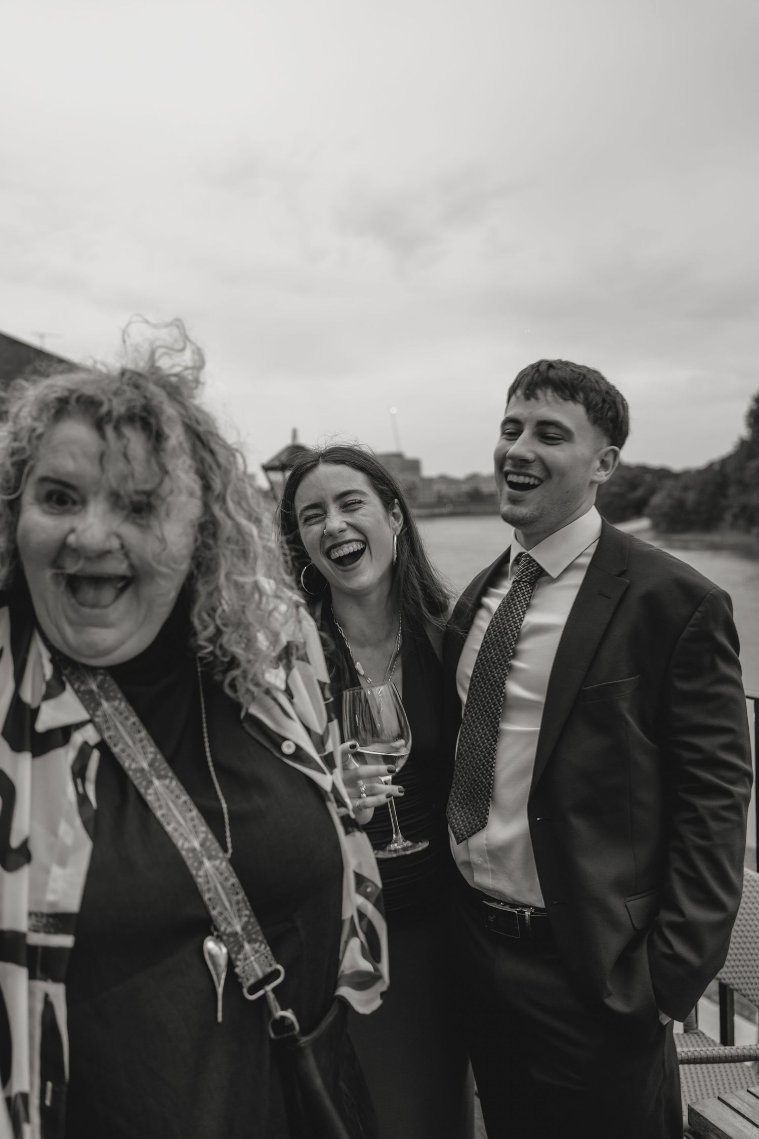 Wedding party members share laughs during an outdoor celebration.