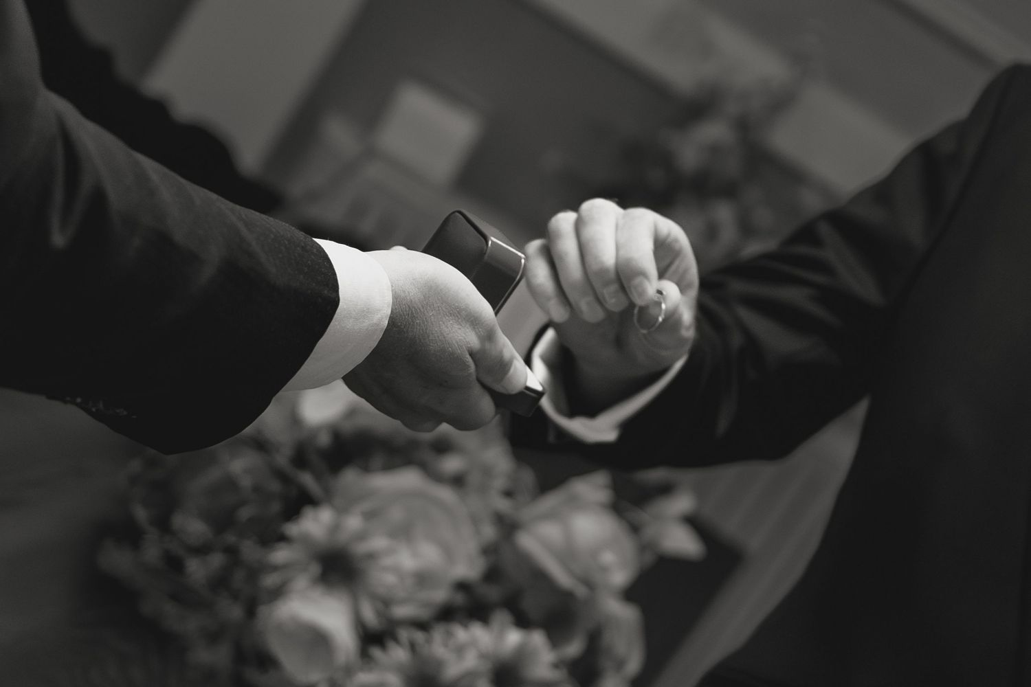 Close-up detail of hands during an intimate wedding moment.