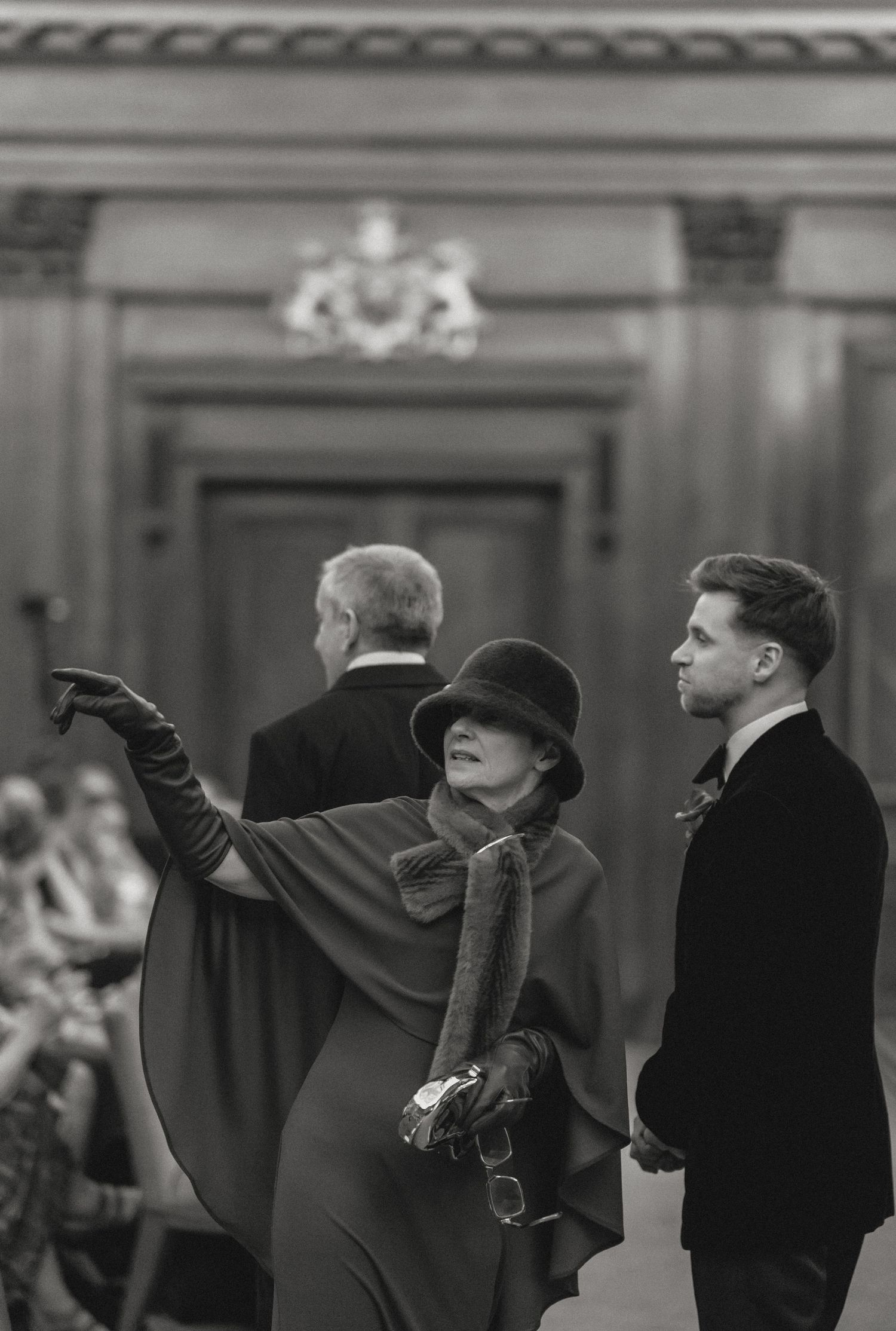 People dancing and celebrating at a formal event with raised arms.