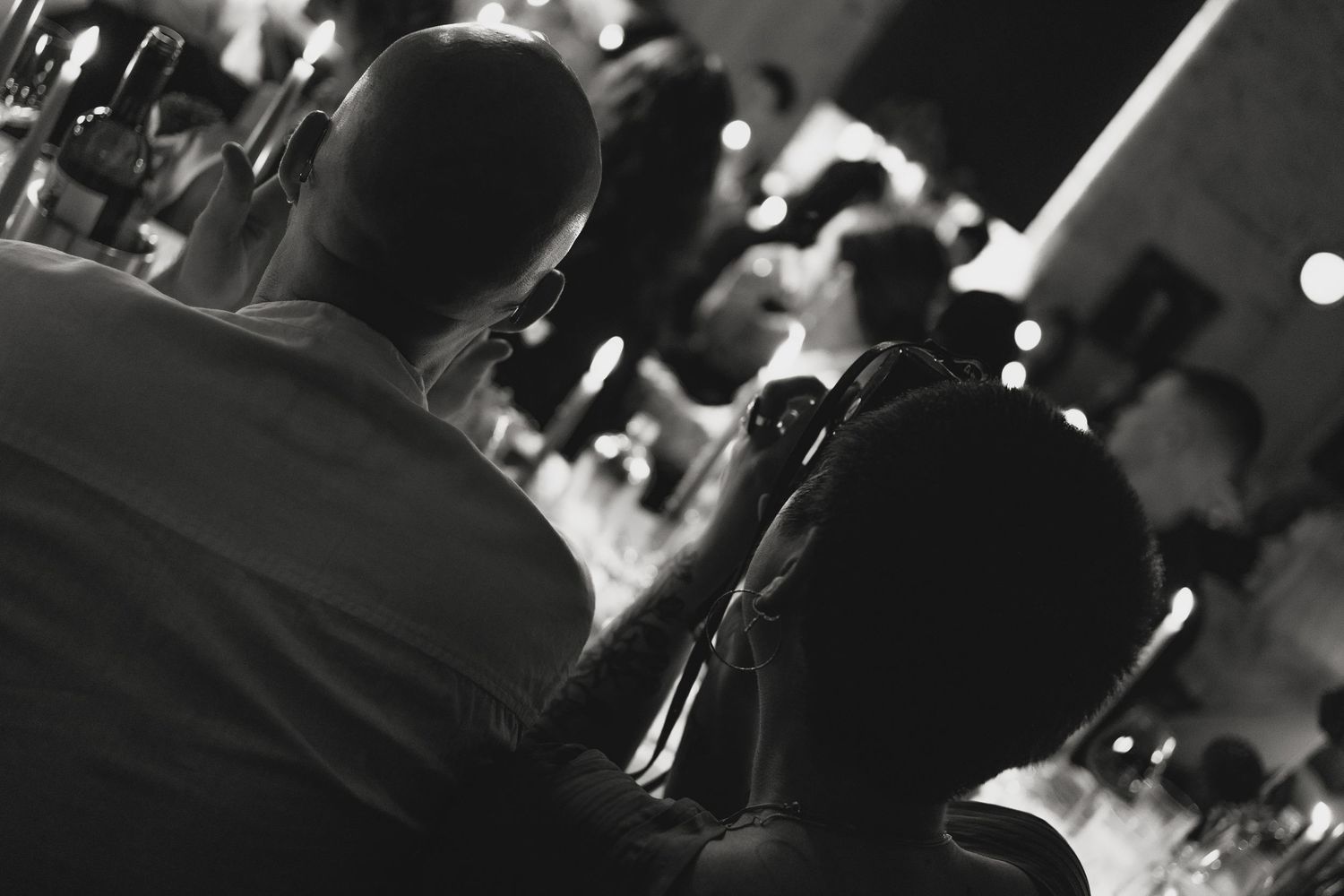 Silhouetted figures in a dimly lit venue during an event.