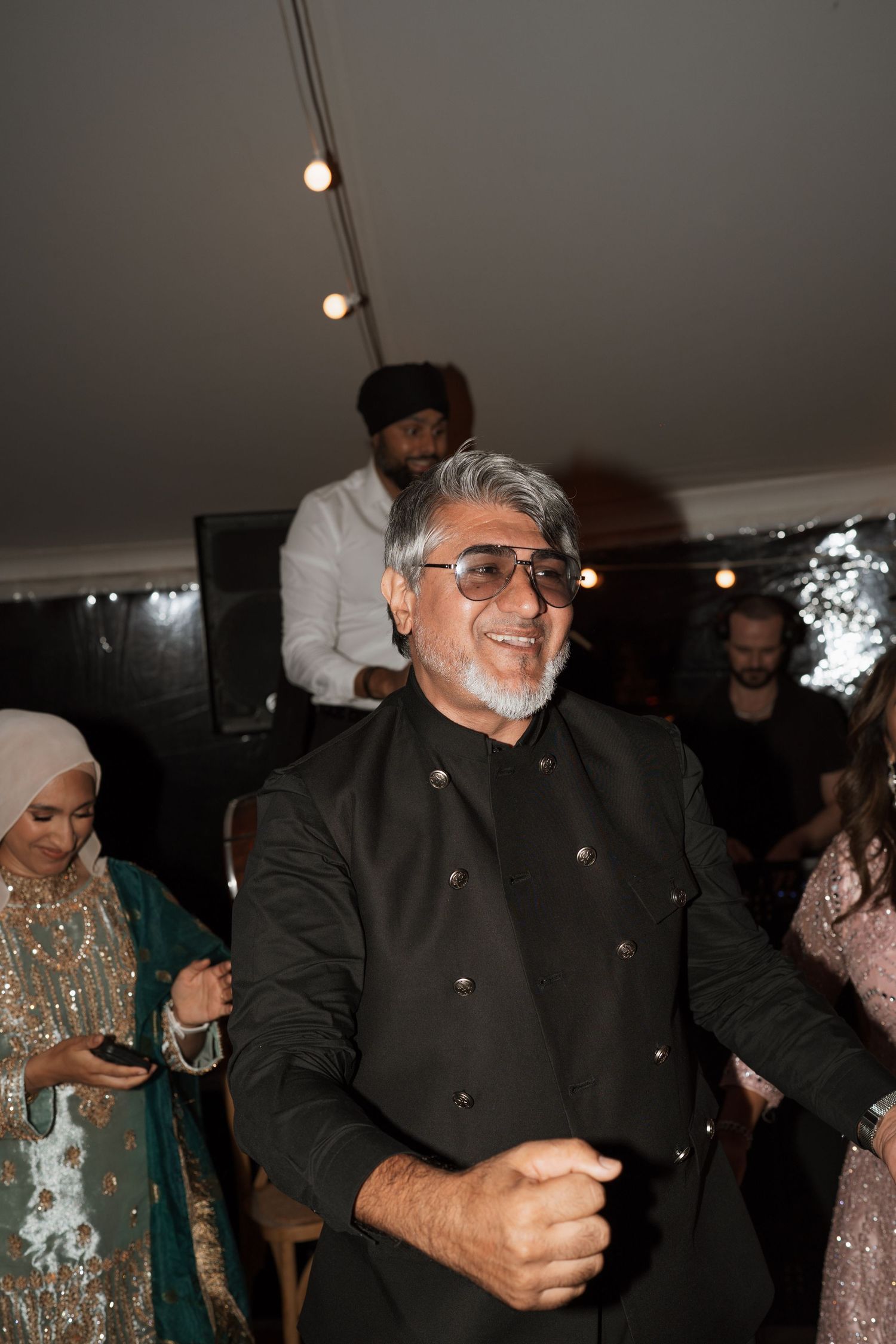 Guests enjoying themselves on a dimly lit dance floor at an evening celebration.