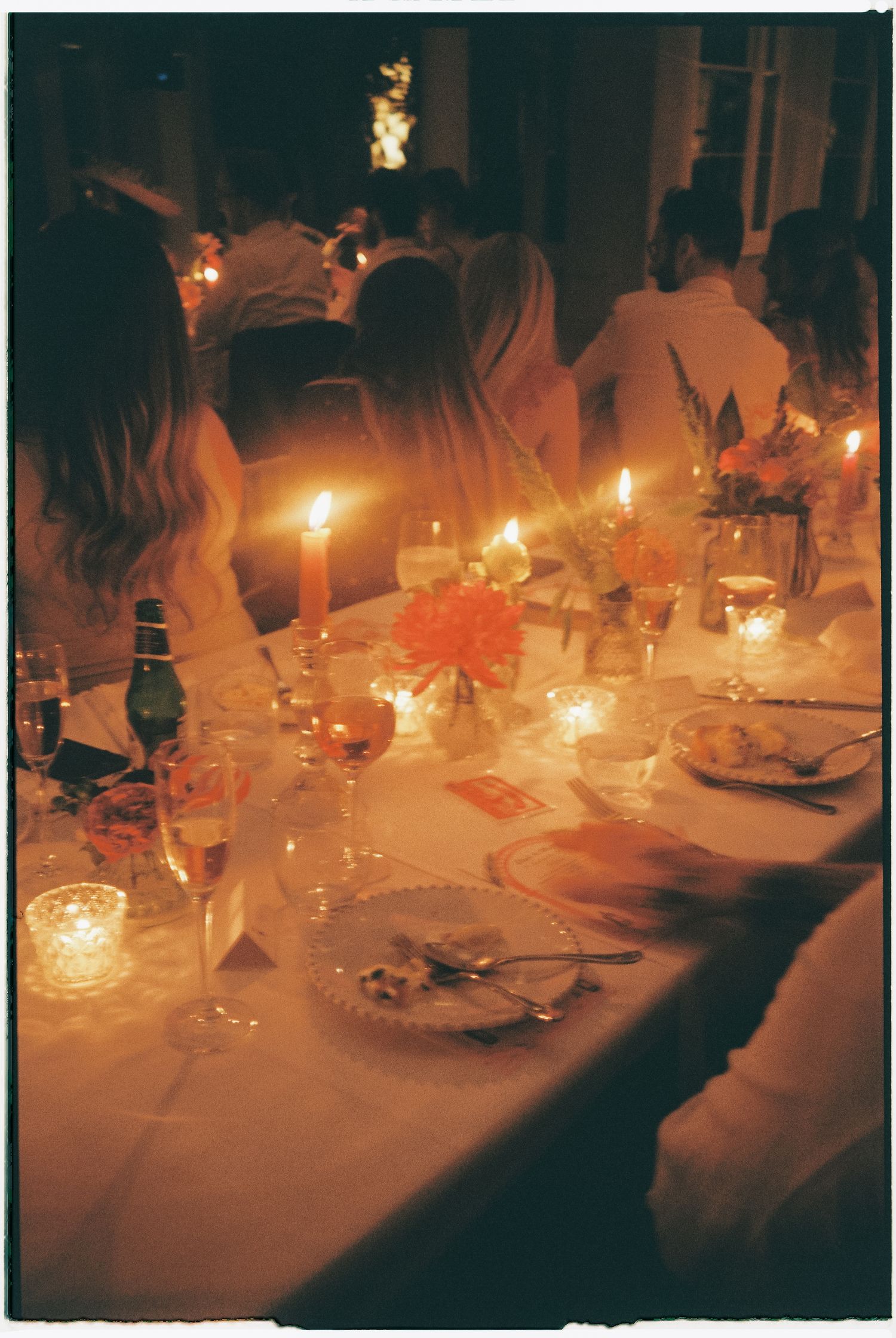 Candlelit dining tables set with elegant place settings create an intimate romantic atmosphere.