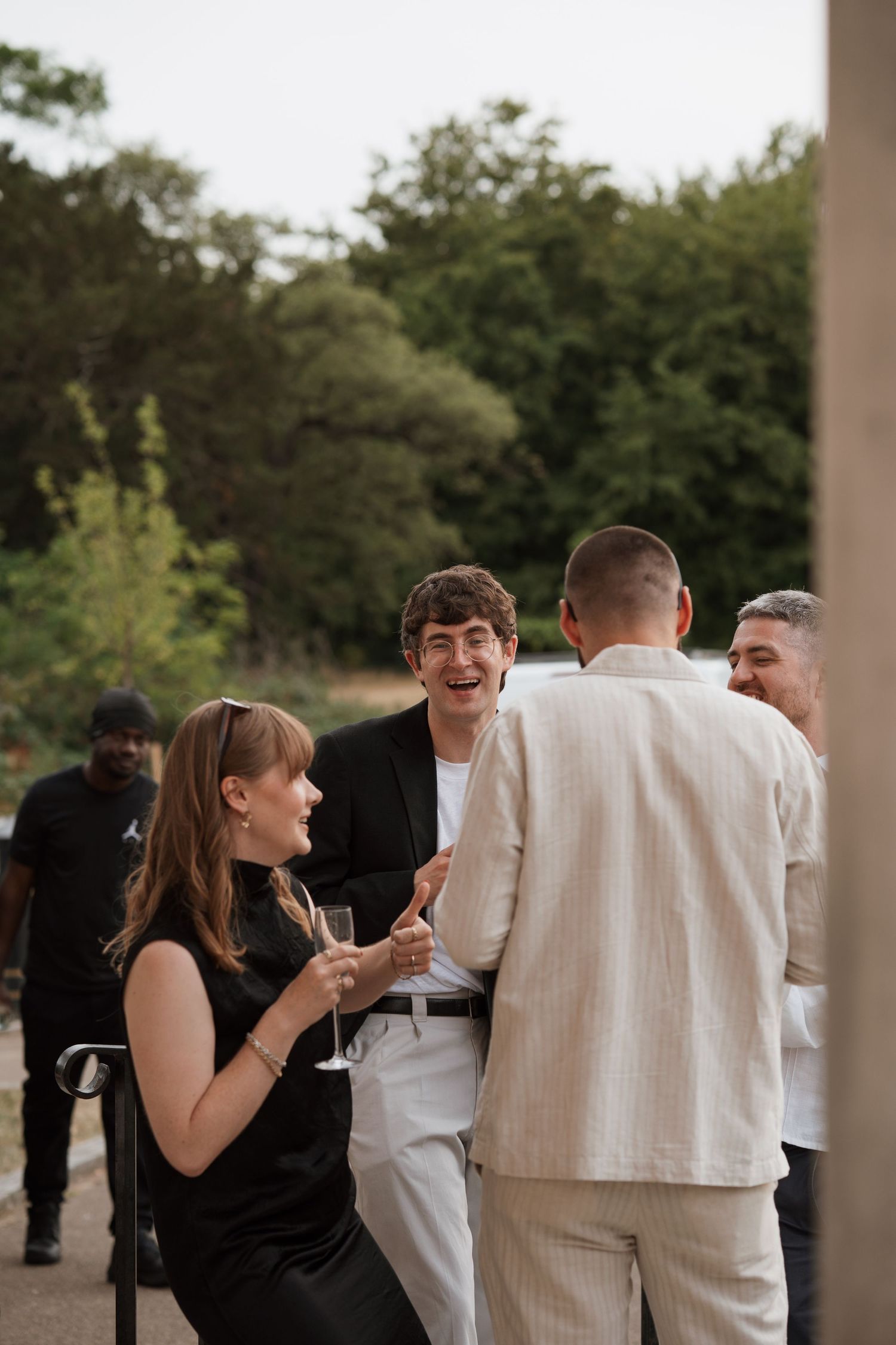 Wedding guests mingling and socializing on a covered patio area.
