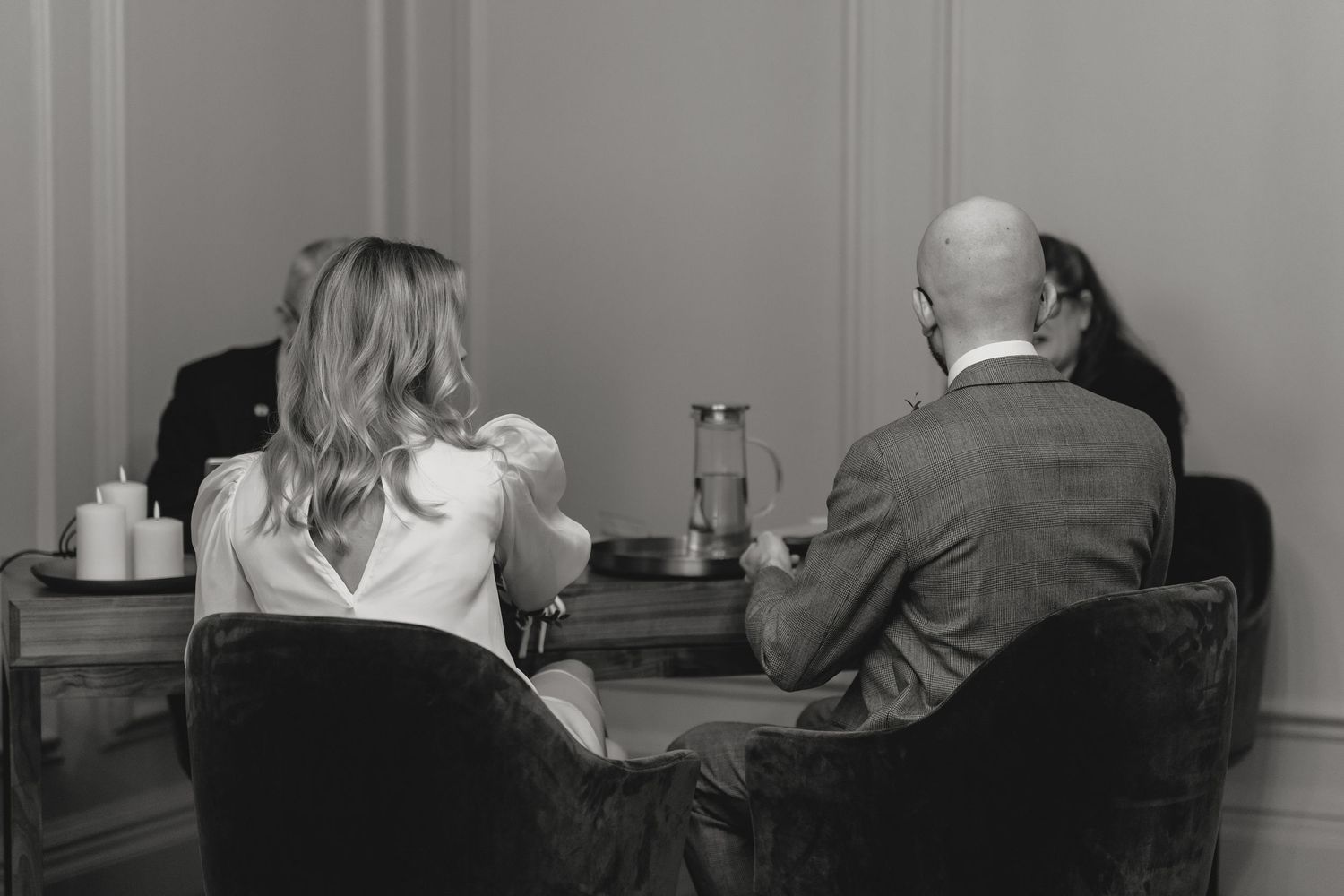 Intimate black and white portraits of people sitting together in a casual indoor setting.