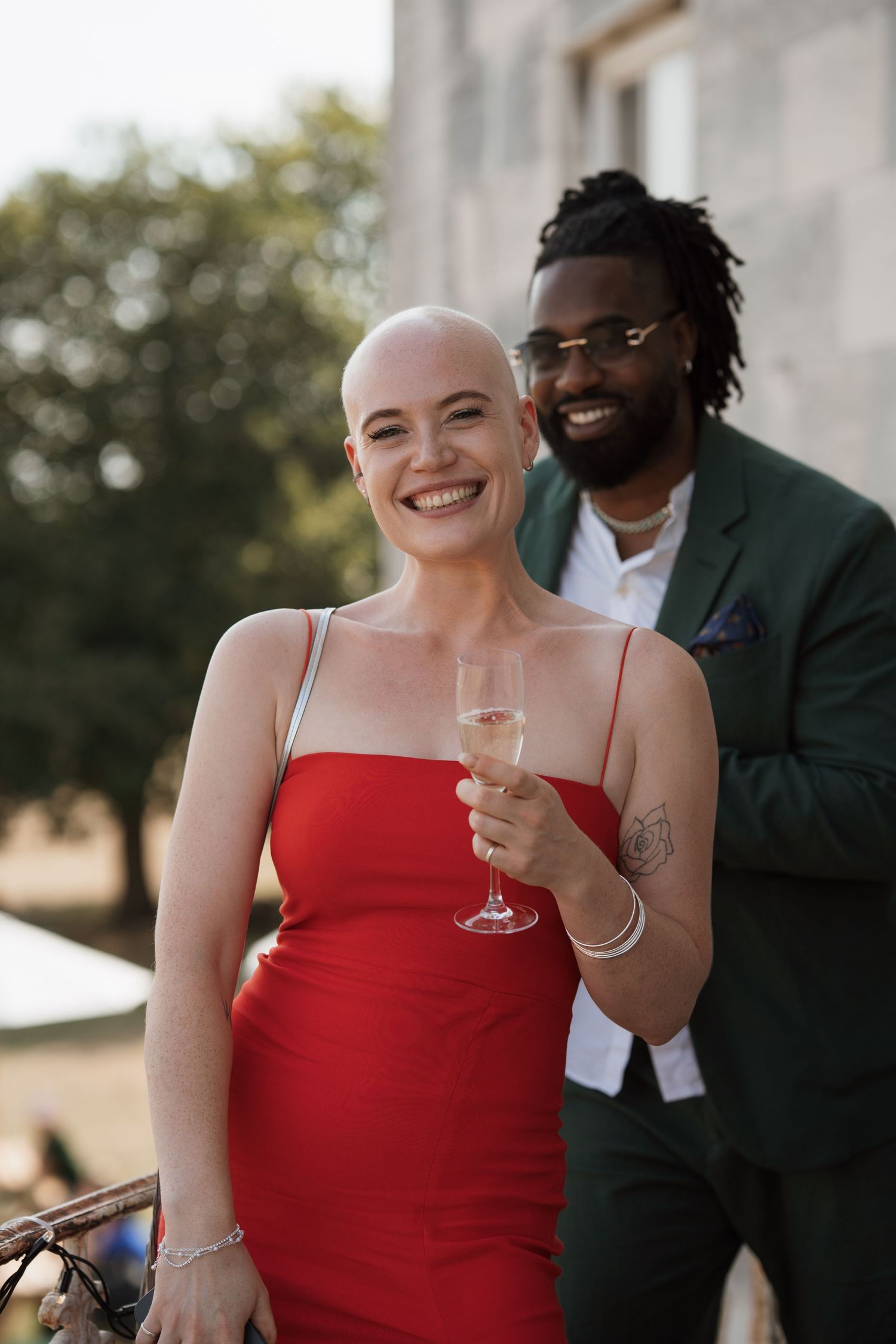 Wedding guests enjoying champagne on elegant outdoor terrace.