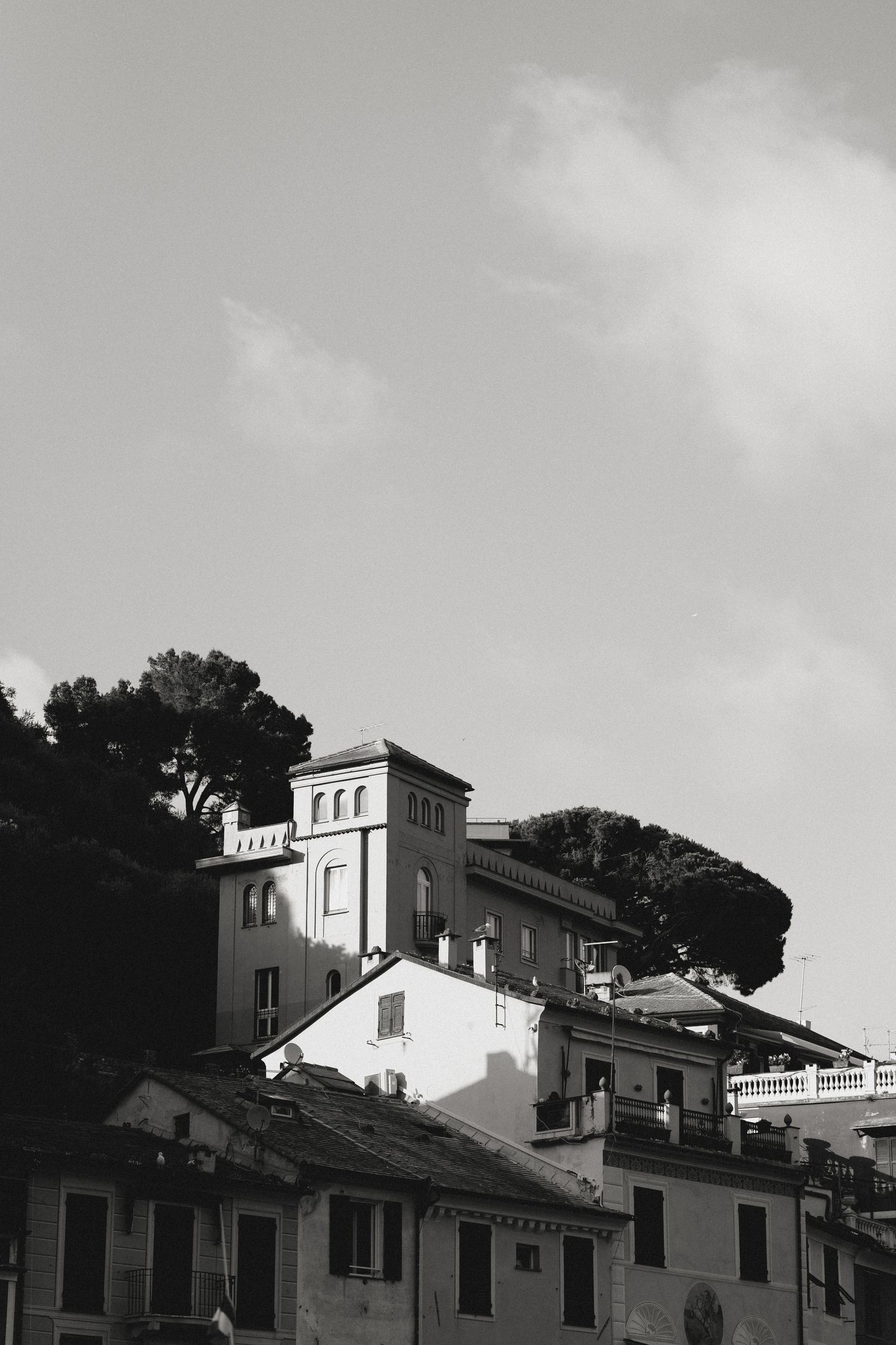 Black and white architectural skyline showing Mediterranean-style buildings against cloudy sky.