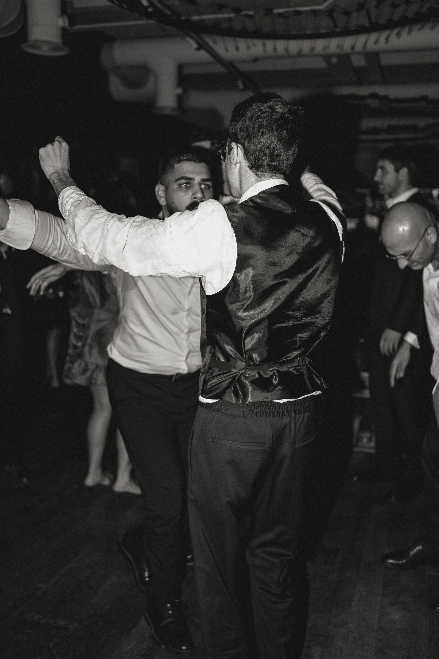 Two people dancing together on a dark dance floor at an event.