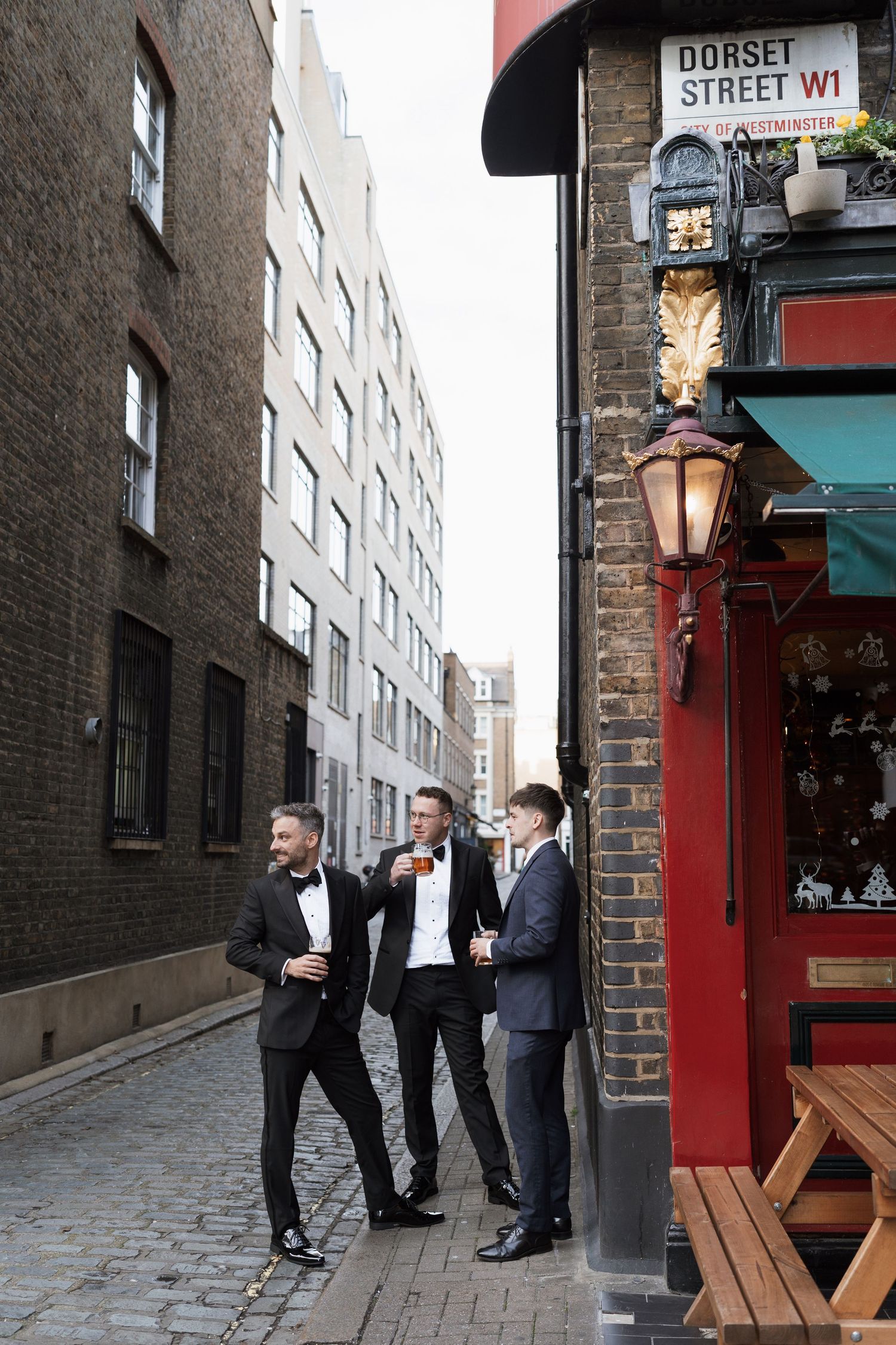 People in suits socializing on Dorset Street outside a pub entrance.