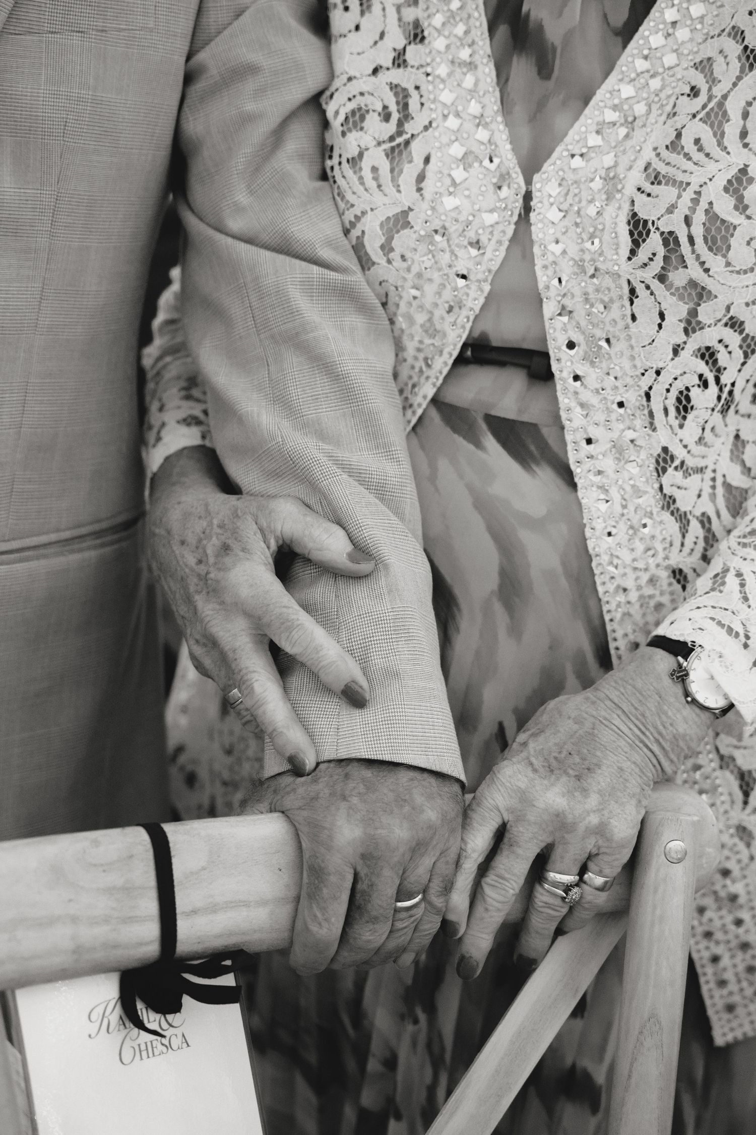 Black and white detail shot of hands holding papers during a wedding ceremony.