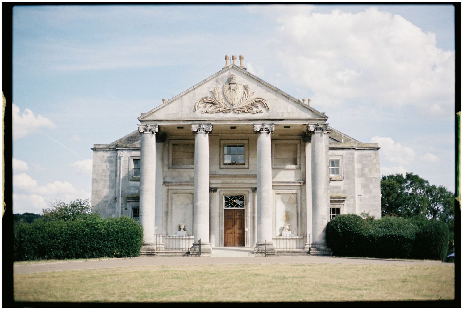 A panoramic view of a grand neoclassical building with white columns and ornate architectural details.