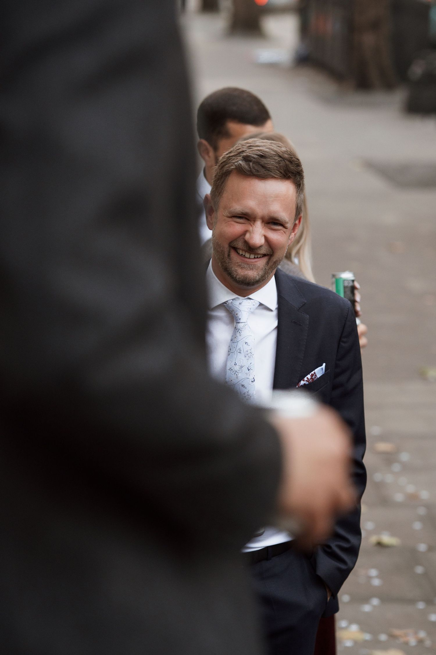 A man in a dark suit smiling at a formal event.