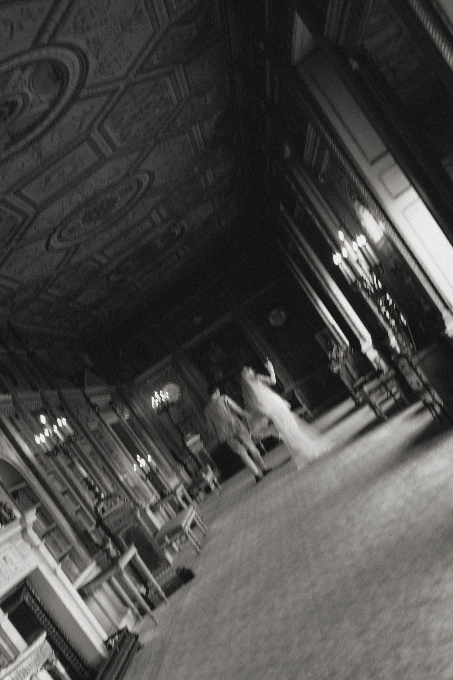 Dark interior of an ornate ballroom with dramatic lighting and architectural details.