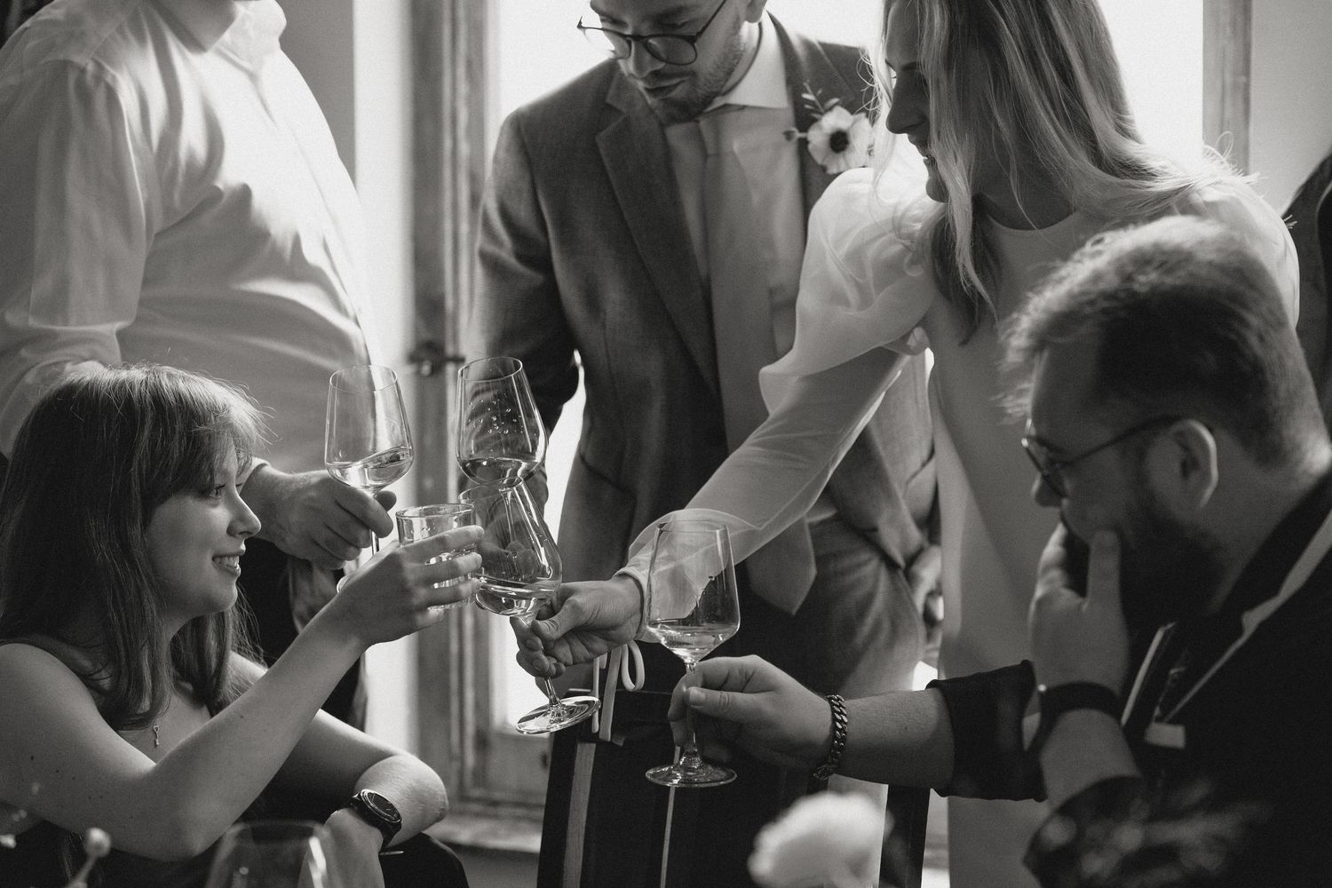 Wedding guests enjoying drinks and conversation at an indoor reception celebration.