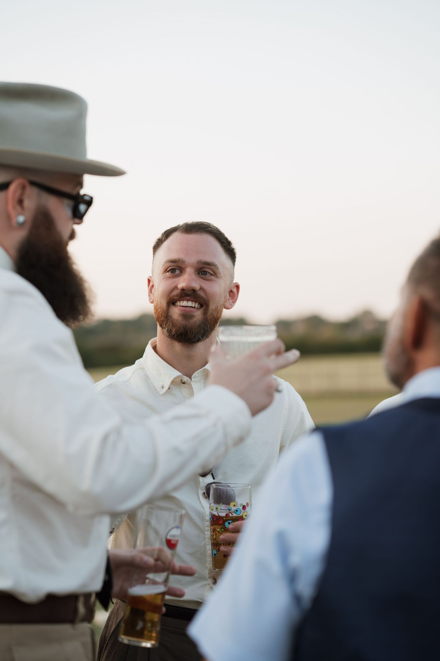 Wedding guests enjoying drinks and conversation at an outdoor reception.