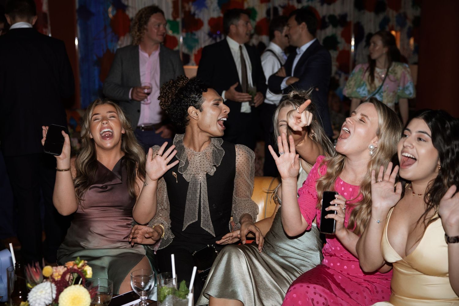 Party crowd dancing and celebrating with enthusiastic expressions.
