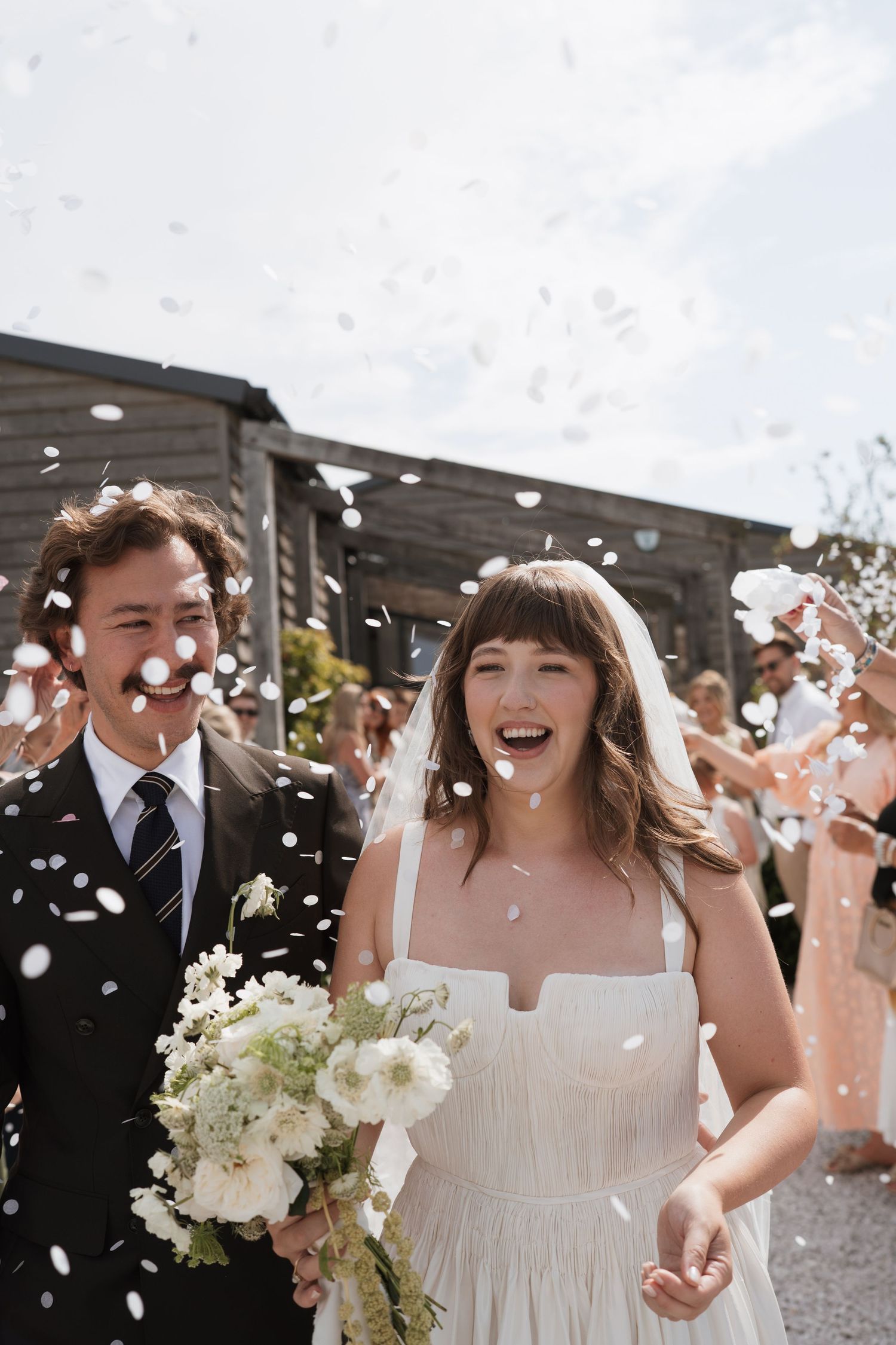 Joyful celebration with confetti toss at outdoor wedding ceremony.