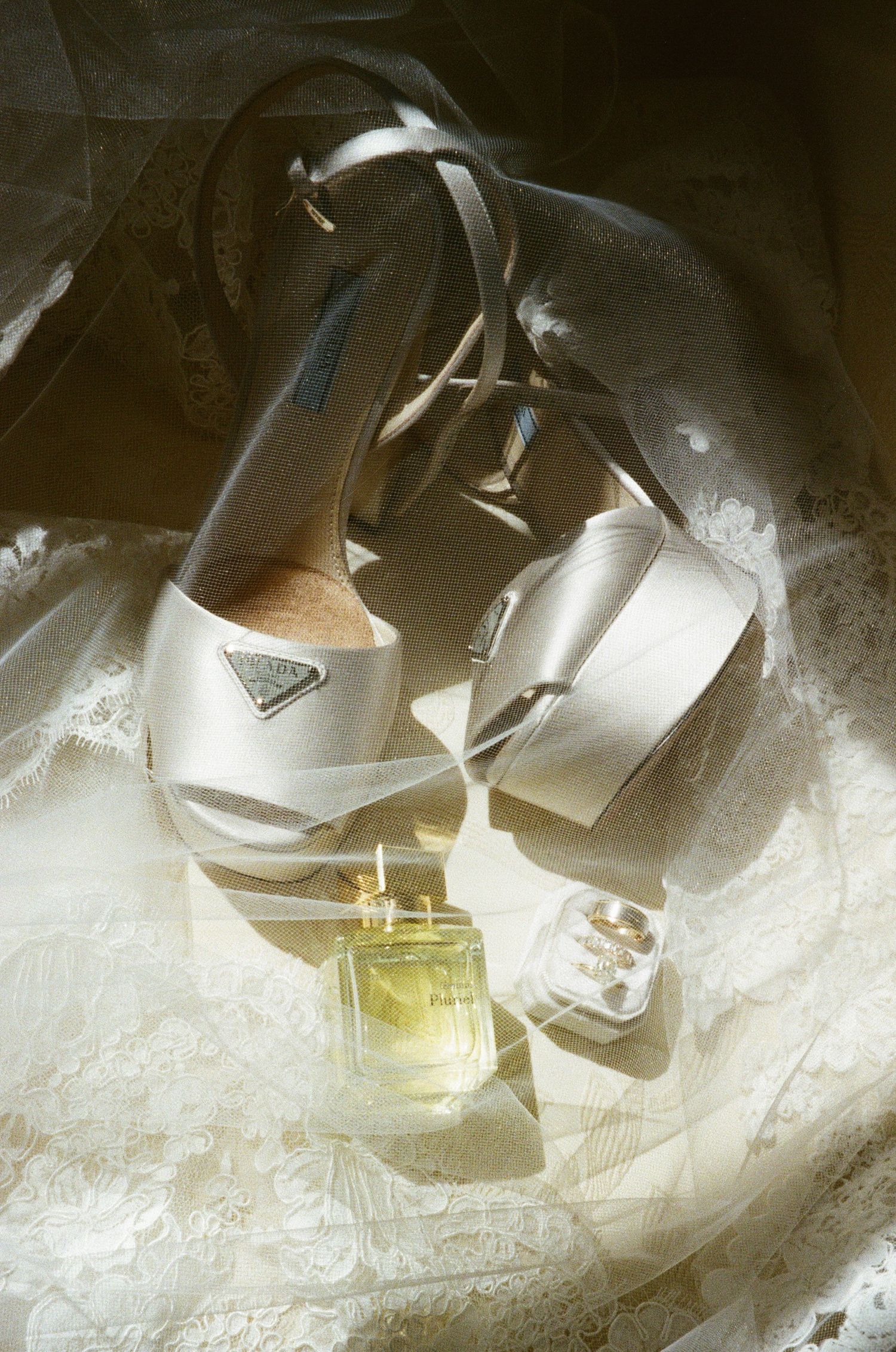 Wedding shoes and accessories artistically arranged on delicate white lace.